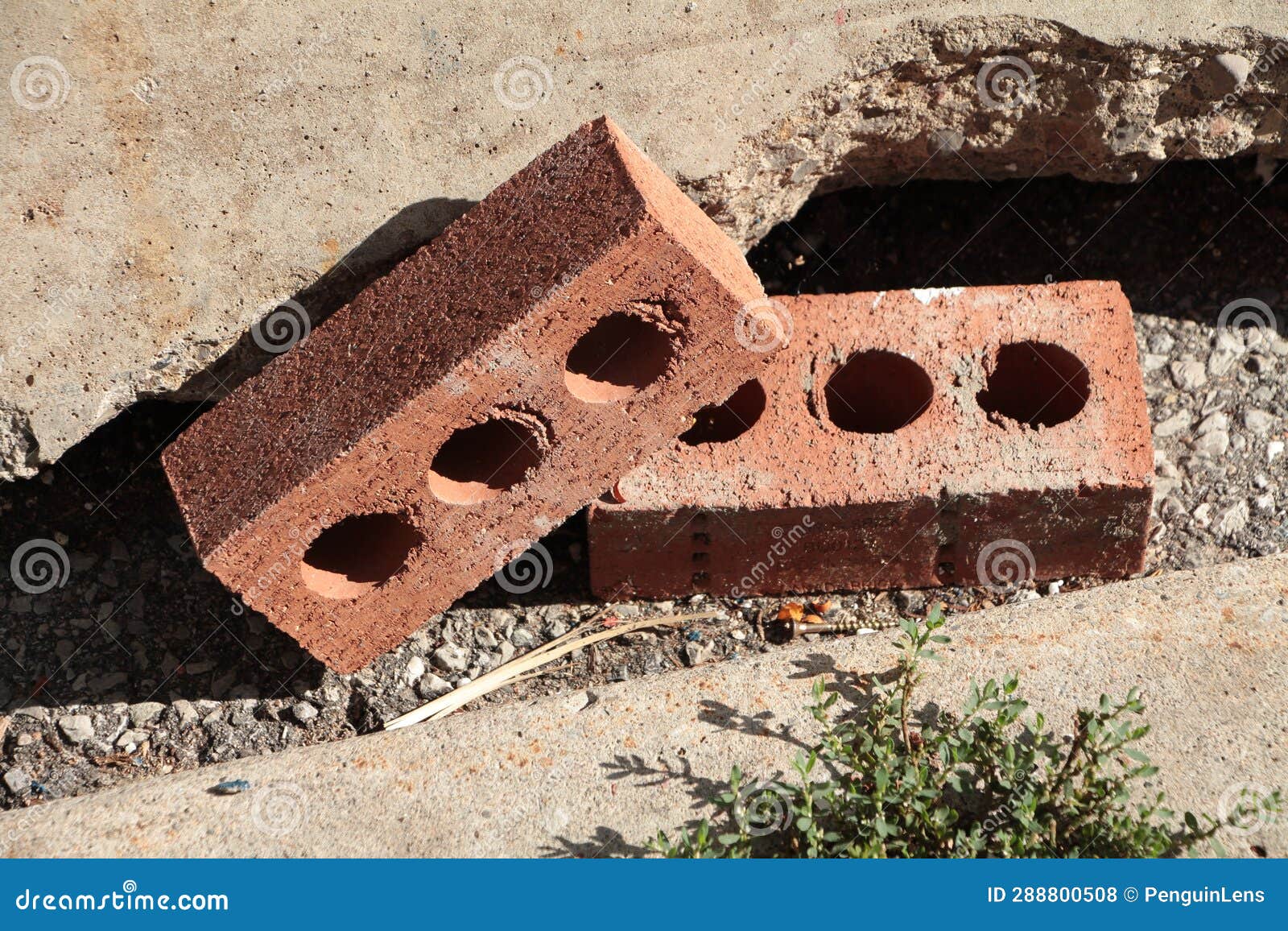 Two Red Bricks with Three Circles Holes in Each Next To Curb with One ...