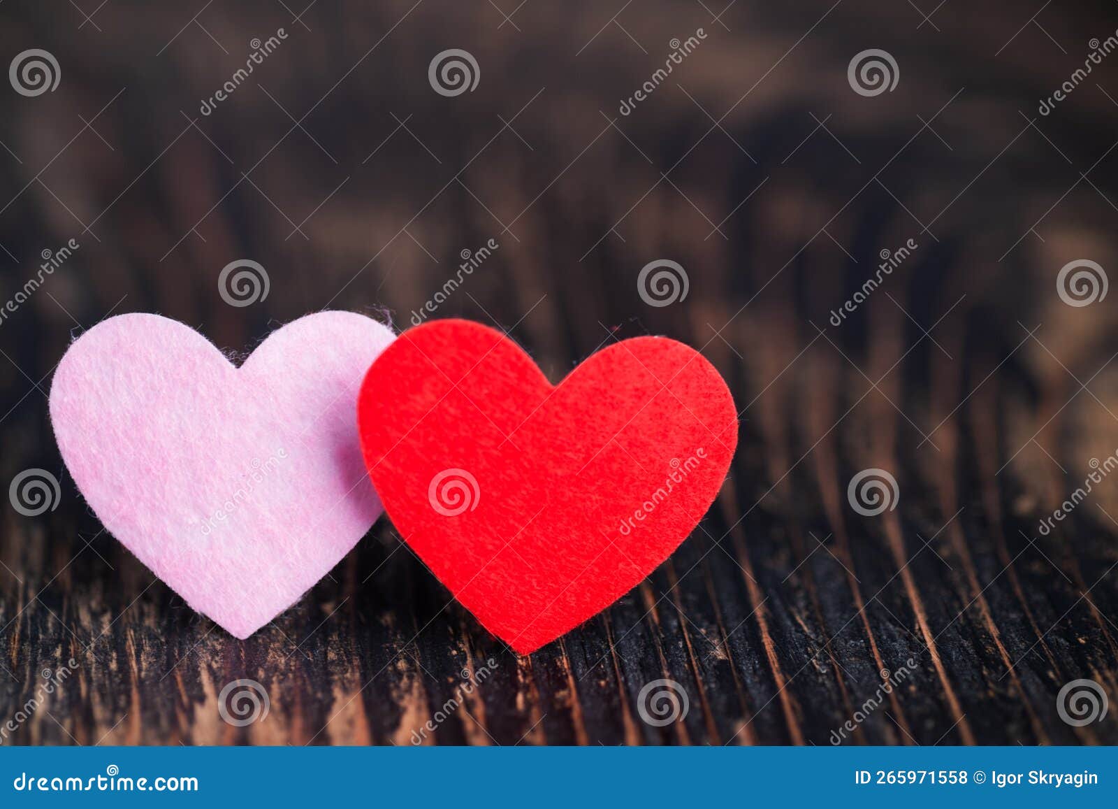 two red hearts on textured dark wooden table love, valentine`s day concept