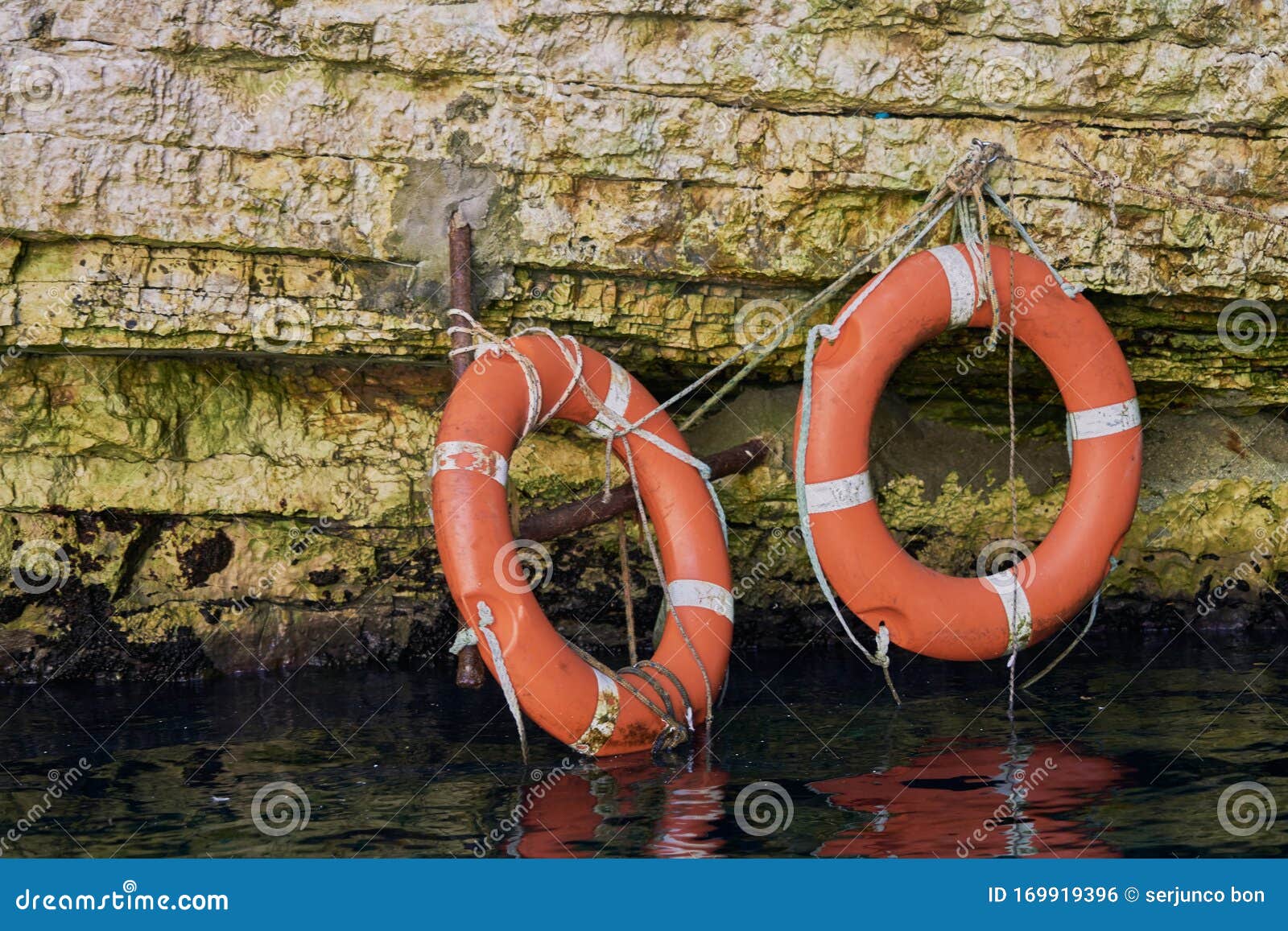 two red lifesavers attached to a cenote wall in greece