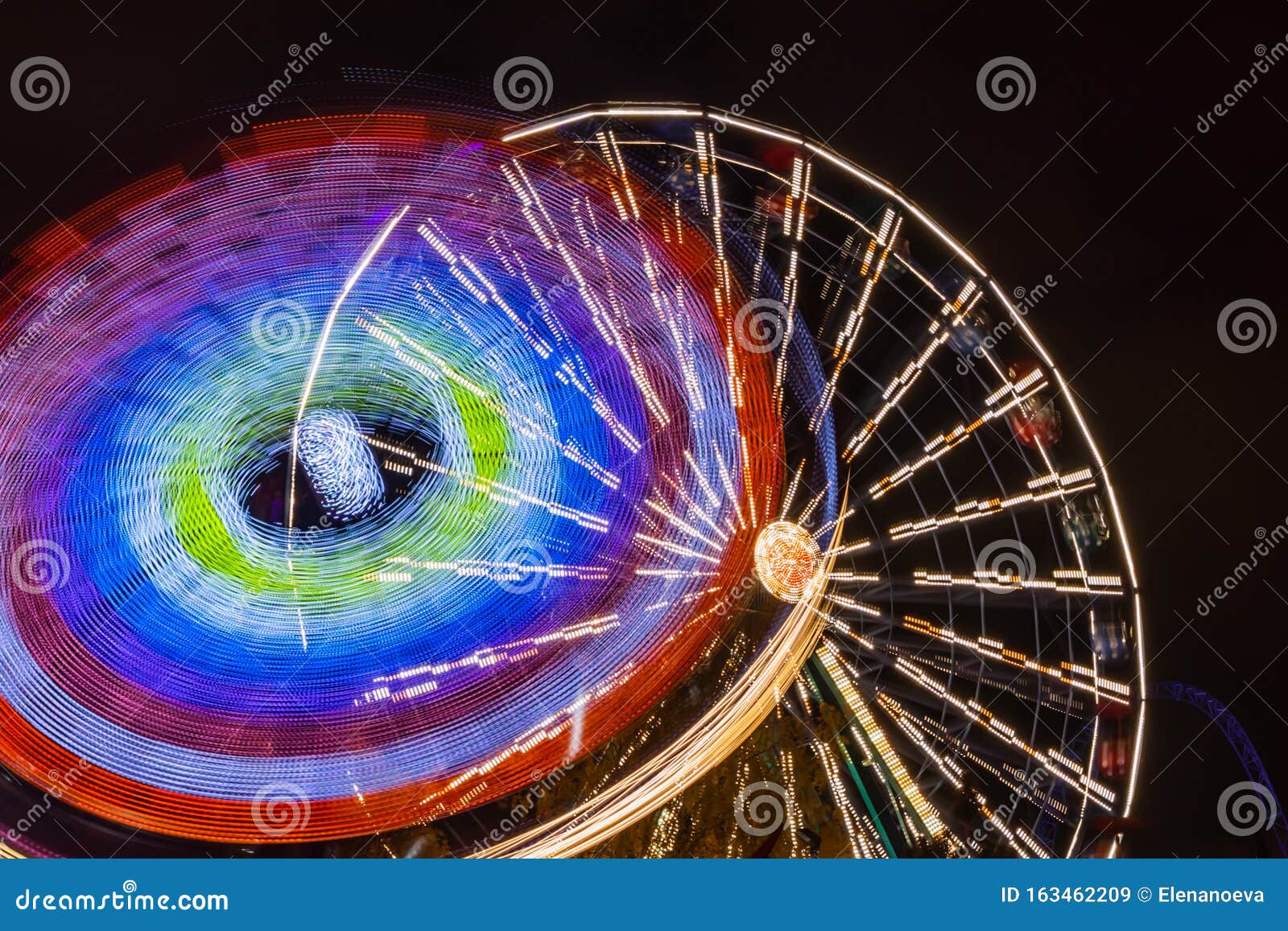 Two Rides in Motion in Amusement Park, Night Illumination. Long