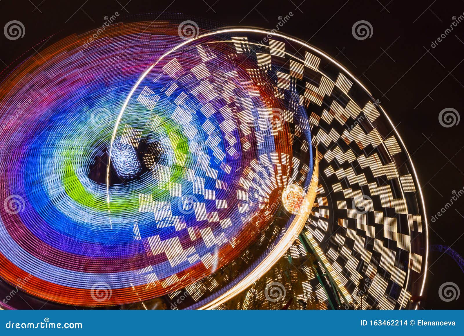 Two Rides in Motion in Amusement Park, Night Illumination. Long