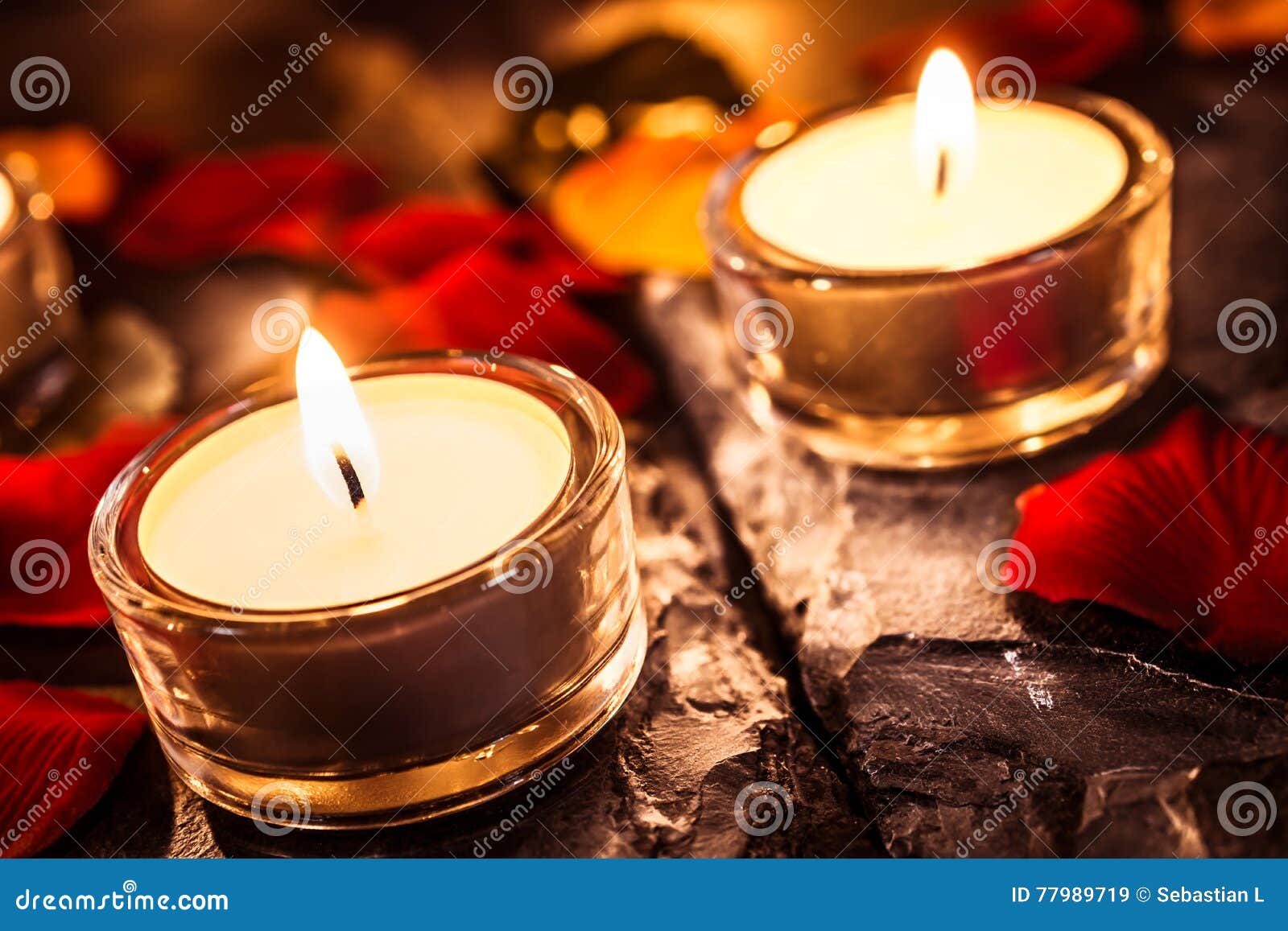Two Romantic Tea Lights on Slate with Rose Petals and Leafs Stock Image