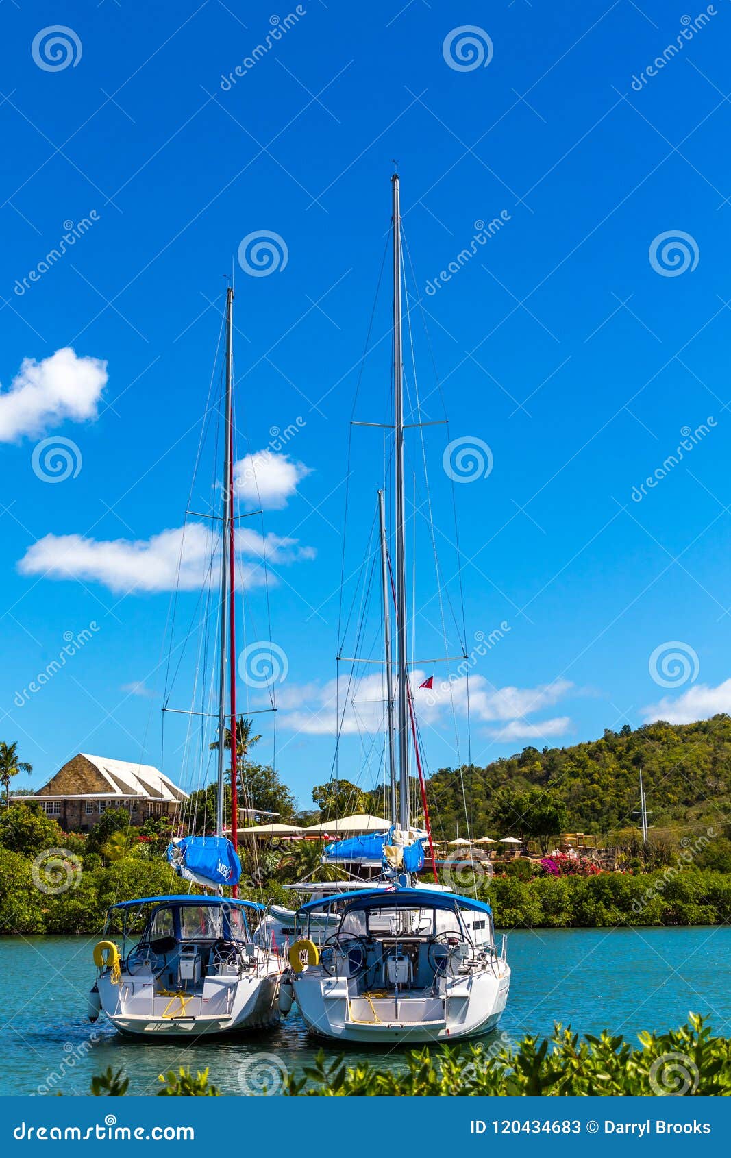 two sailboats leave a harbor in the bahamas