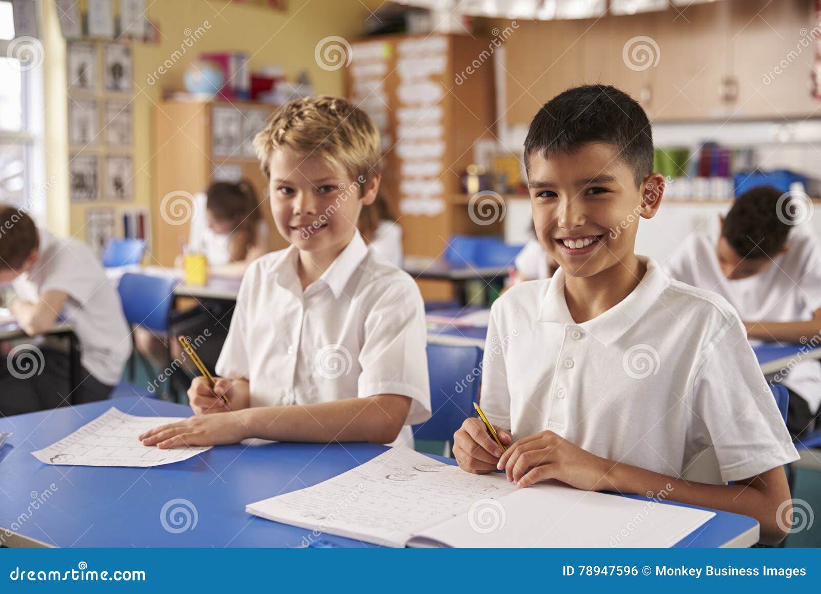 two schoolboys in a primary school class, looking to camera