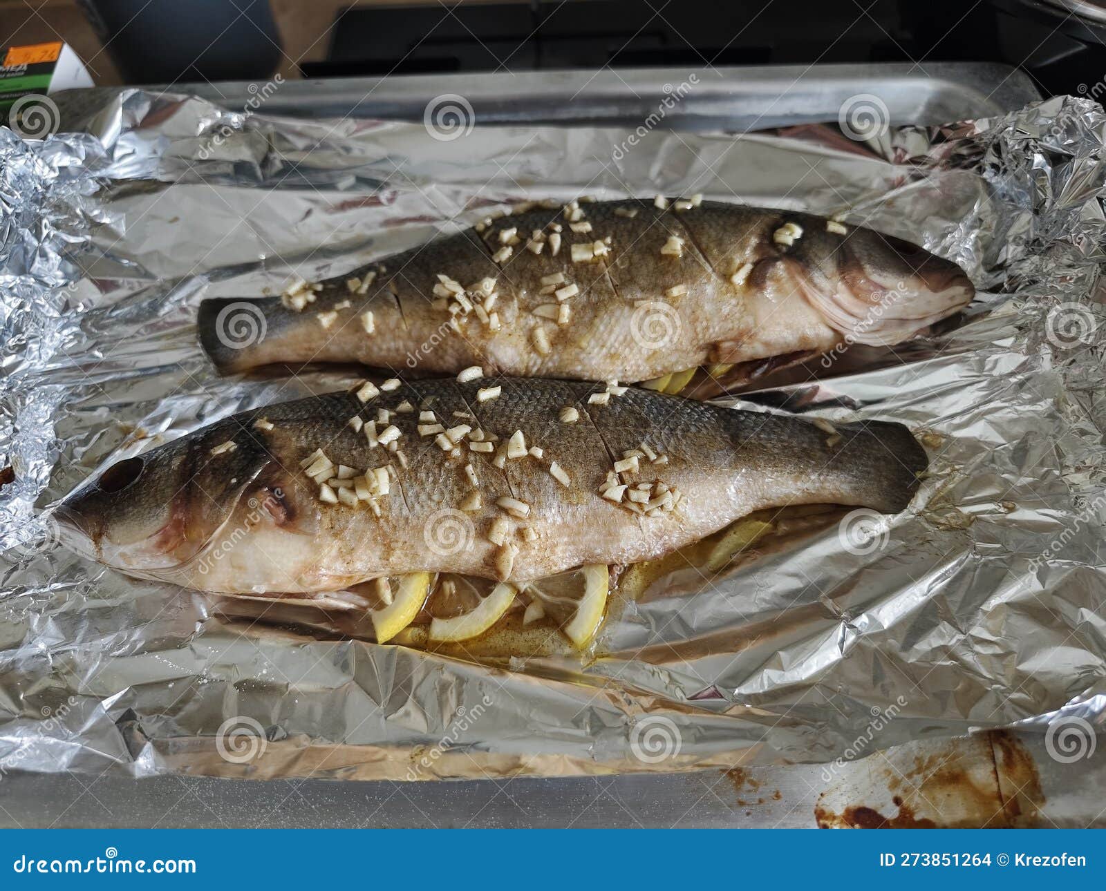 Two Sea Bass Fish Marinated and Laid Out on a Baking Tray Stock Photo