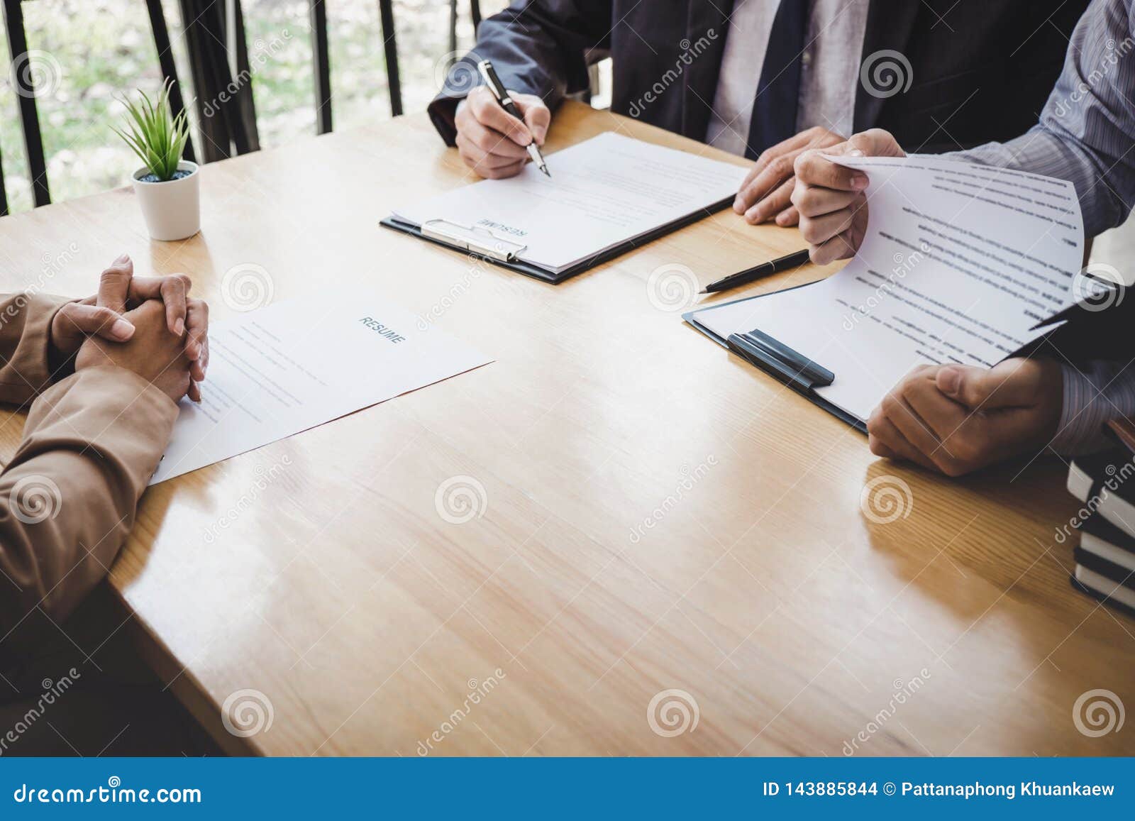 two selection committee manager reading a resume during a job interview, employer interviewing to ask young female job seeker for