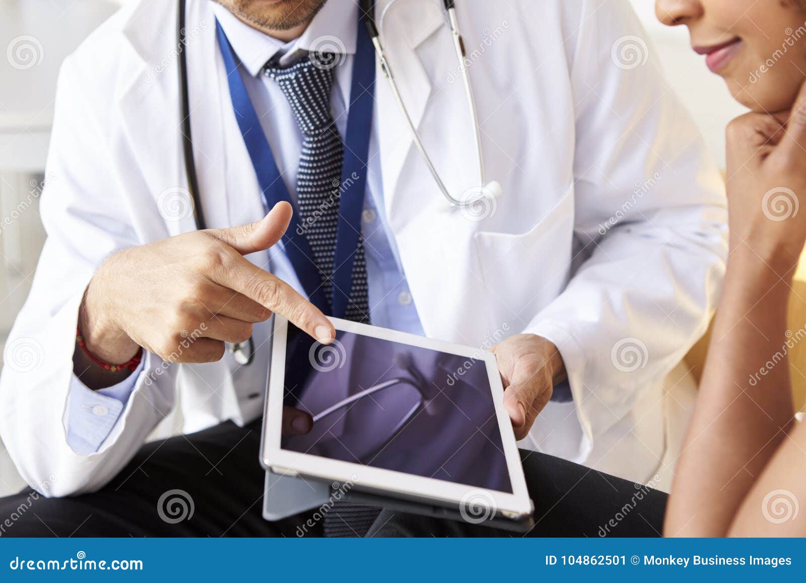 two senior doctors using tablet computer, mid section