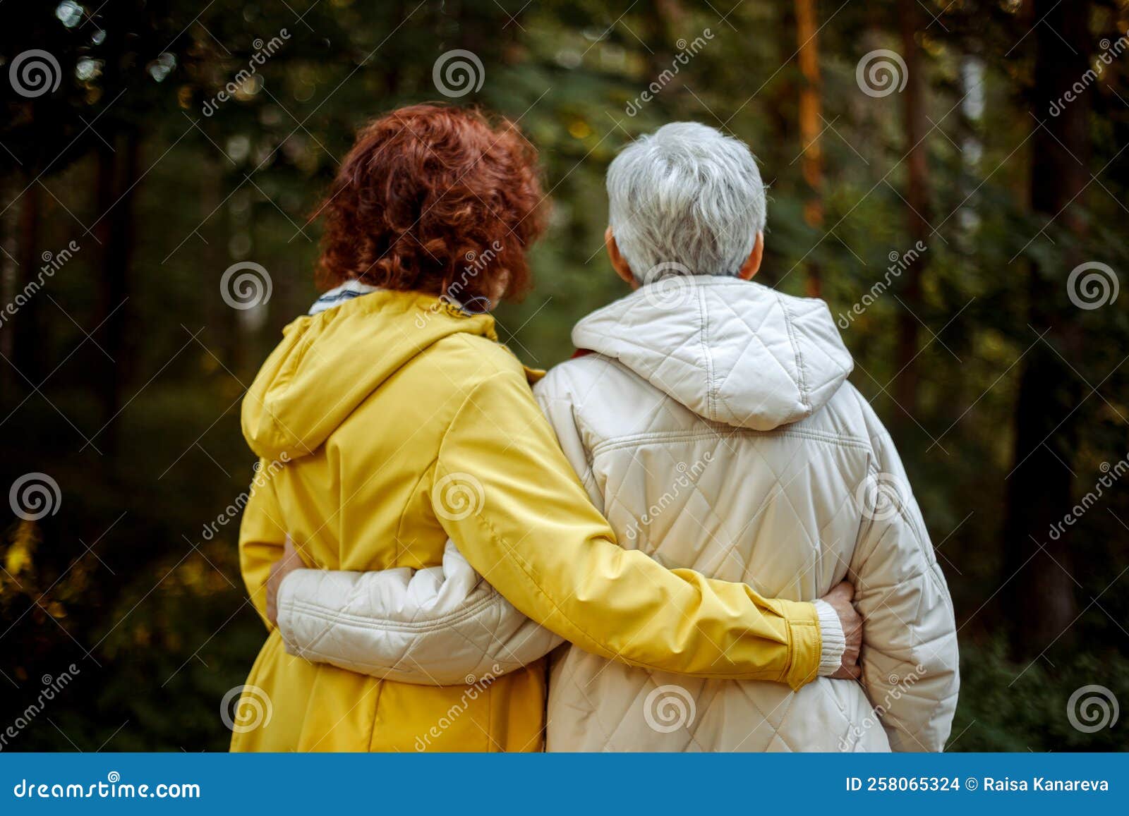 Two Senior Female Friends Hiking Together Through The Forest In Autumn