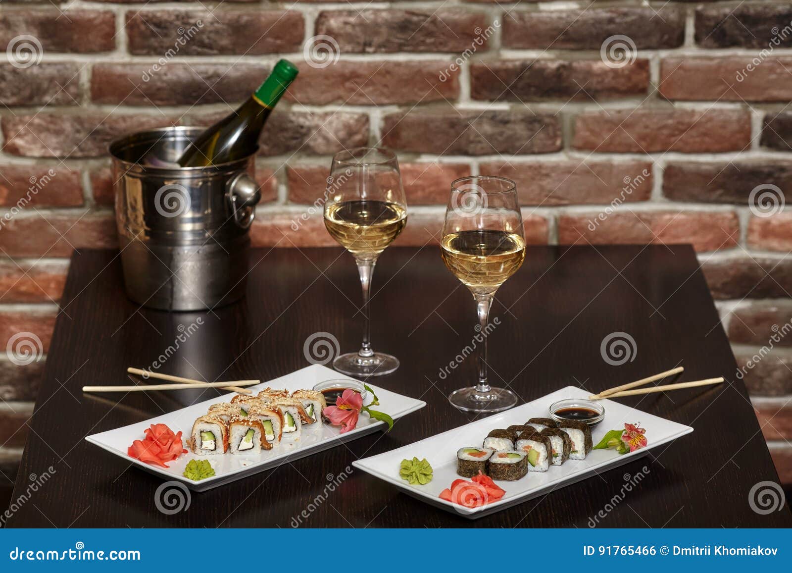 Two Sets of Sushi Rolls with Chopsticks and Wine Glasses Stock Photo