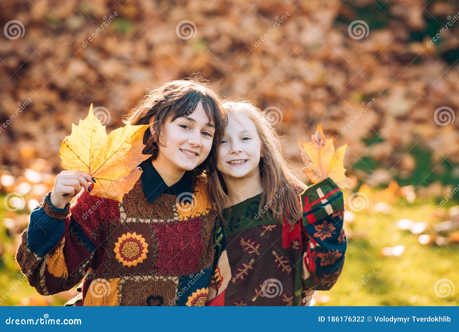 Two Sisters Girls with Autumn Orange Leaves. Healthy and Natural Woman ...