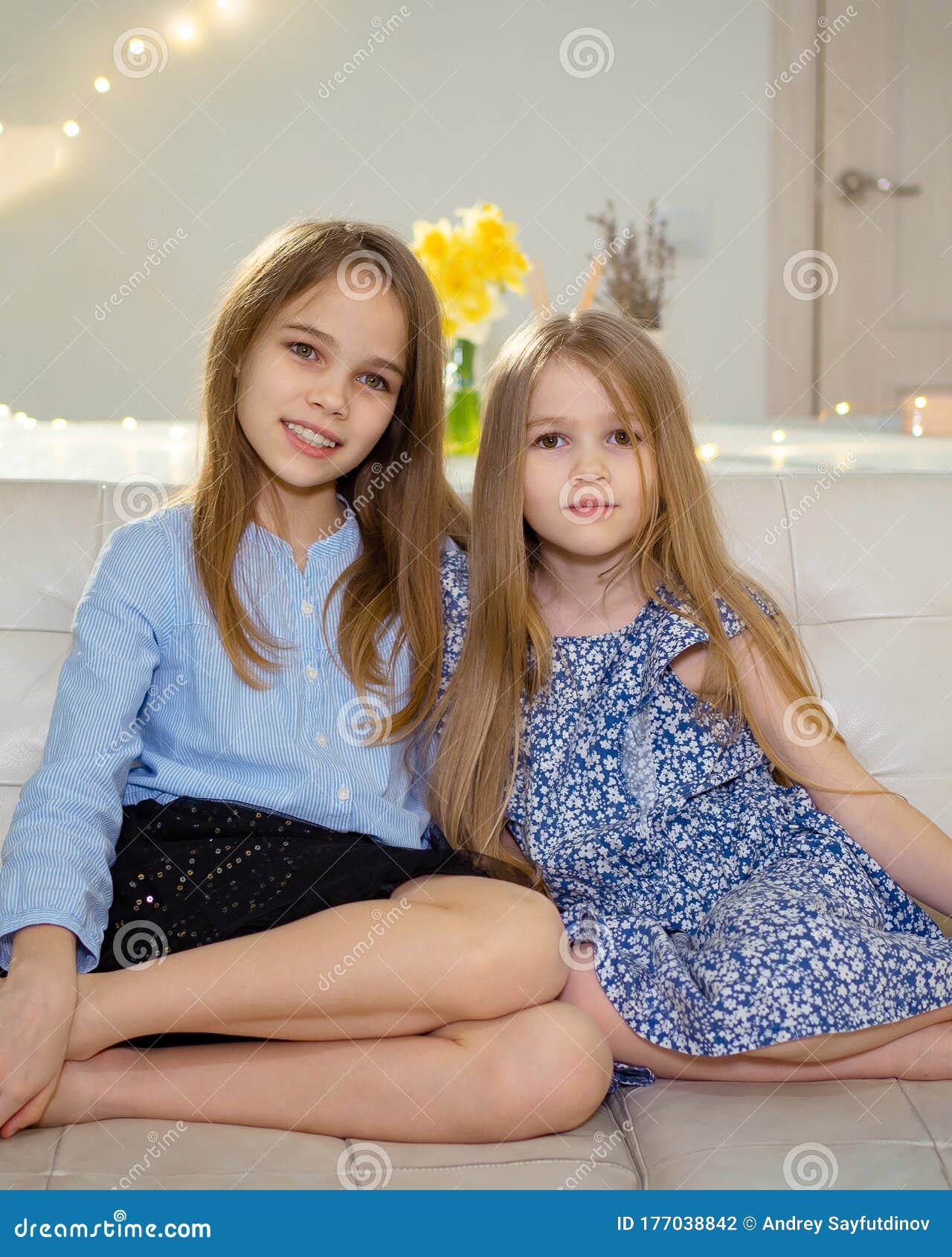 Two Sisters Sit on White Sofa at Home and Watch TV Stock Photo - Image ...