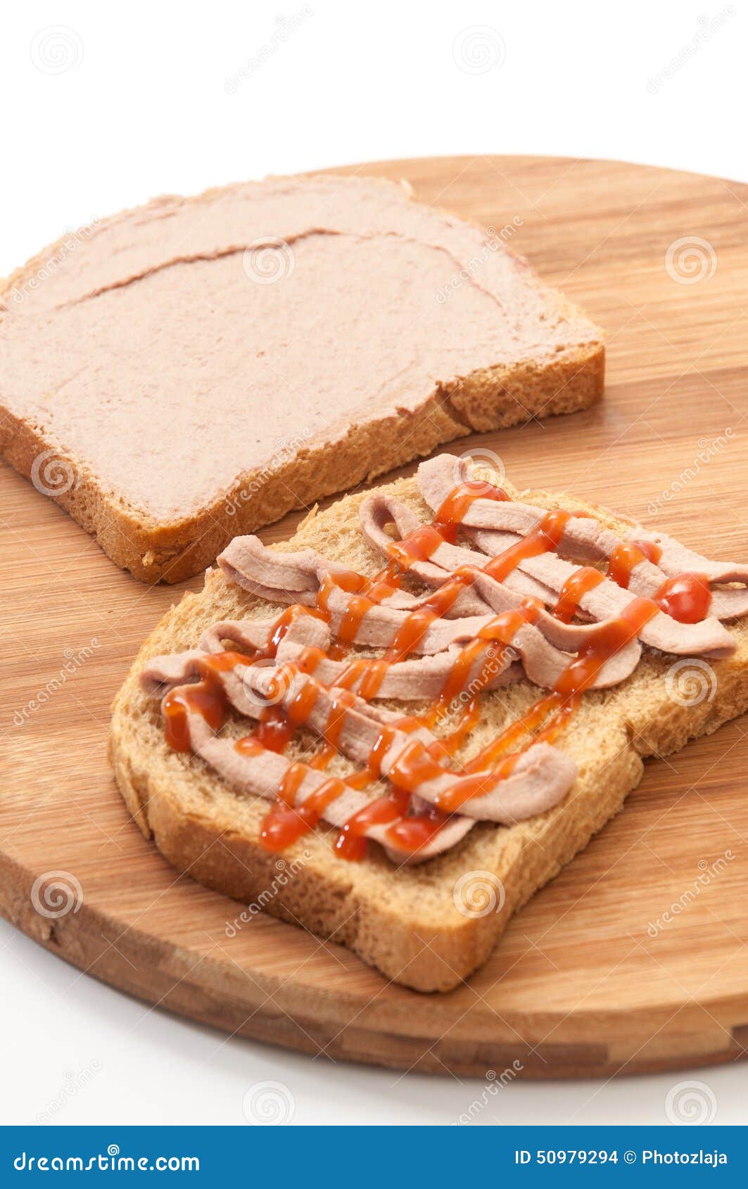 Two Slices of Bread Coated with Pate and Ketchup on Wooden Board Stock