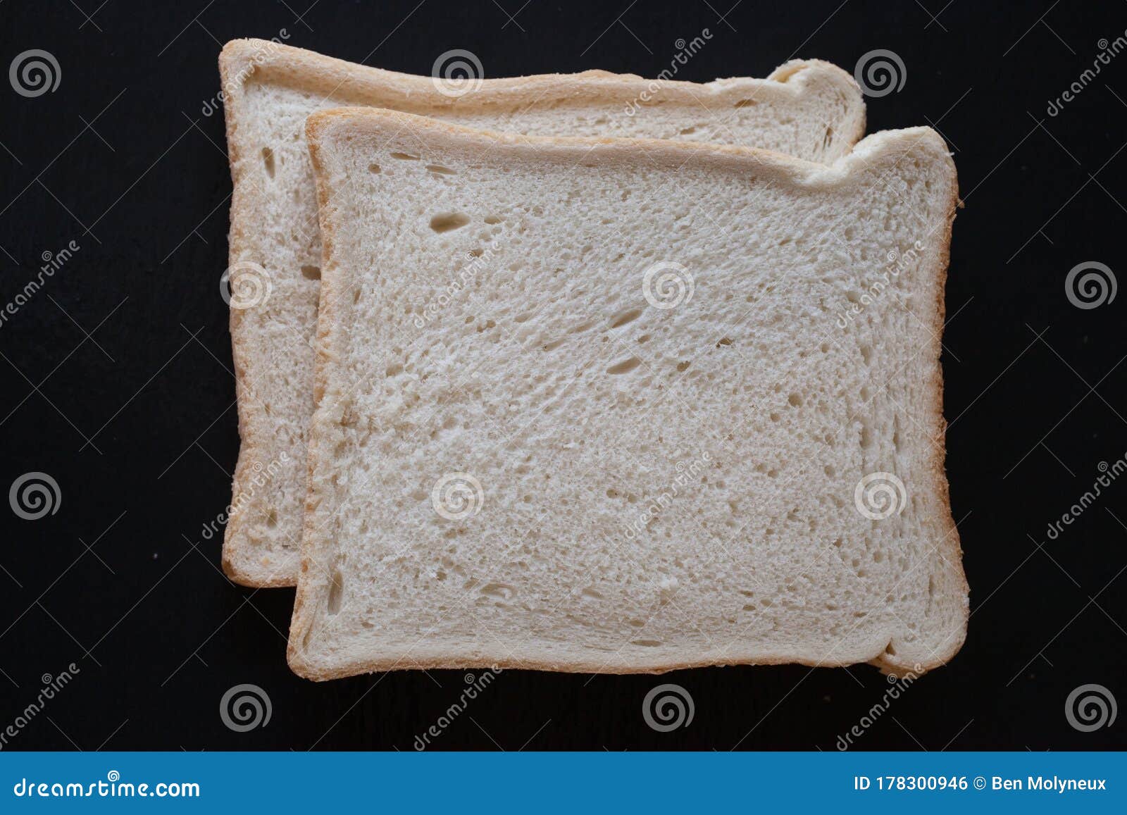 two slices of white bread on a black background