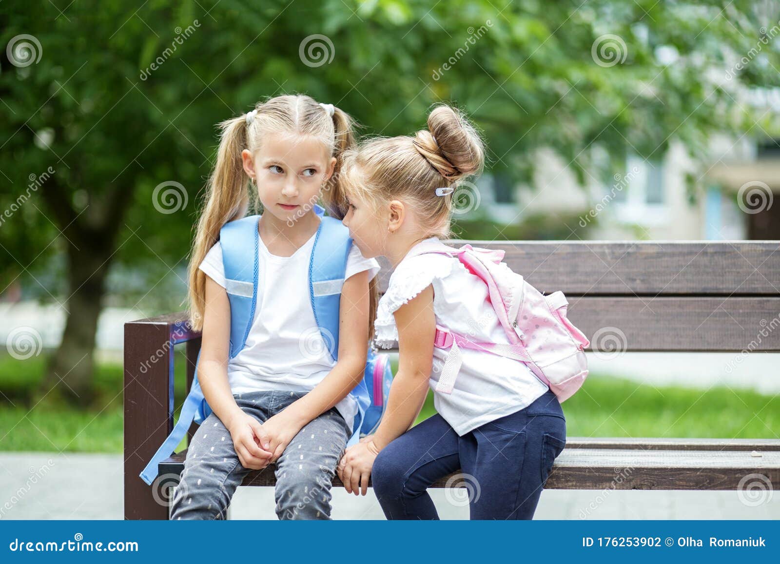 Two Small Children Gossip On A Bench. The Concept Is Back