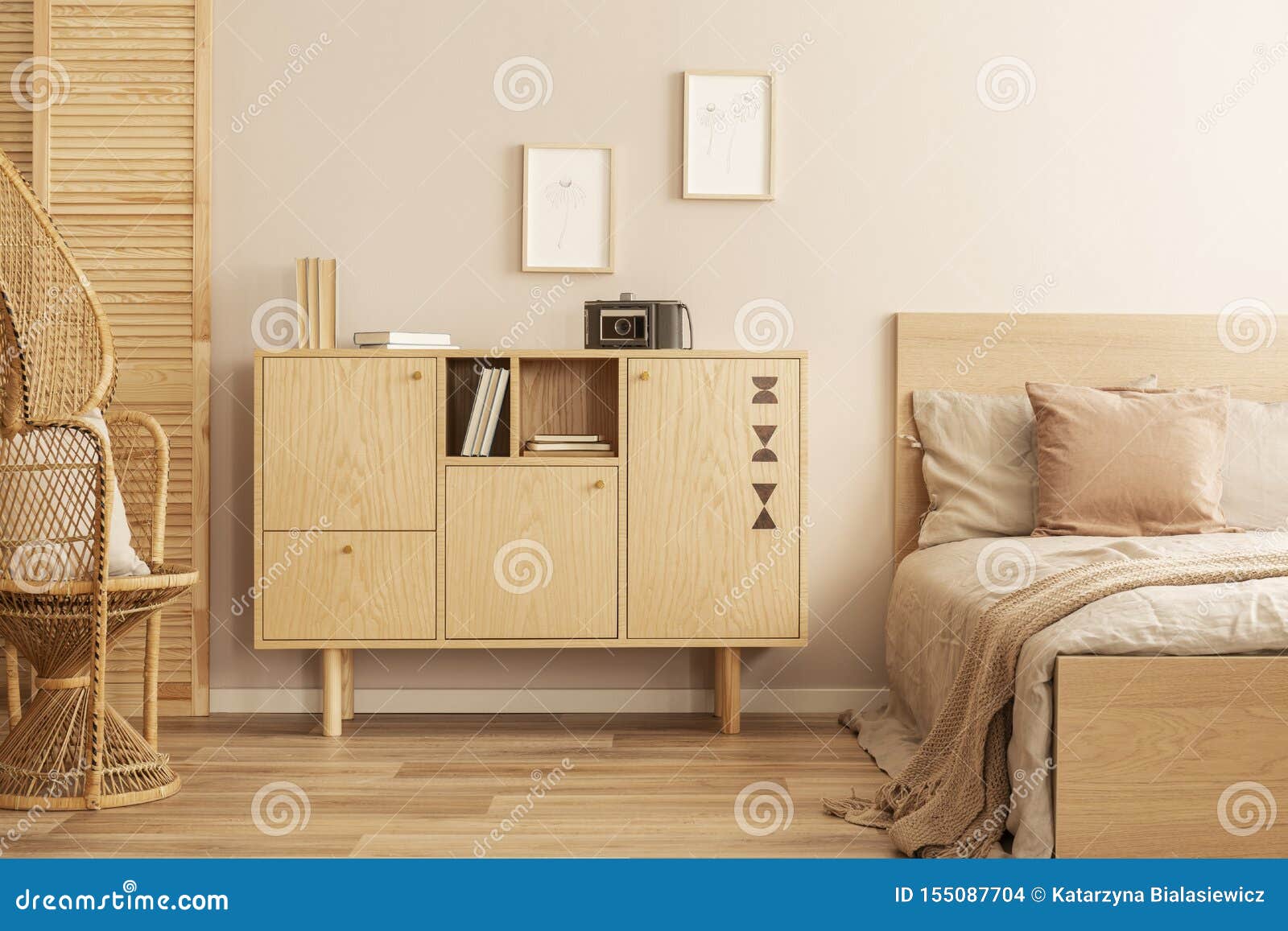 Two Small Graphics In Wooden Frames On Empty Wall Of Stylish