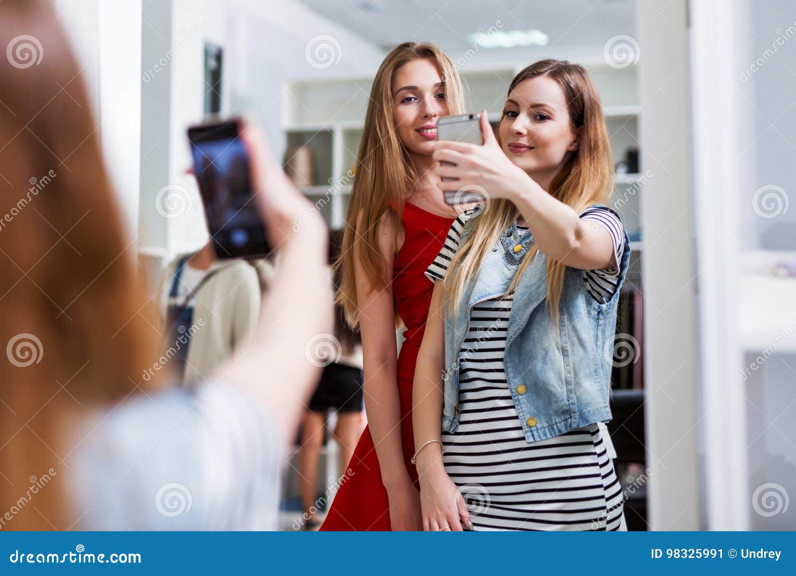 Two Smiling Girls Taking Selfie while Shopping in a Clothing Store ...