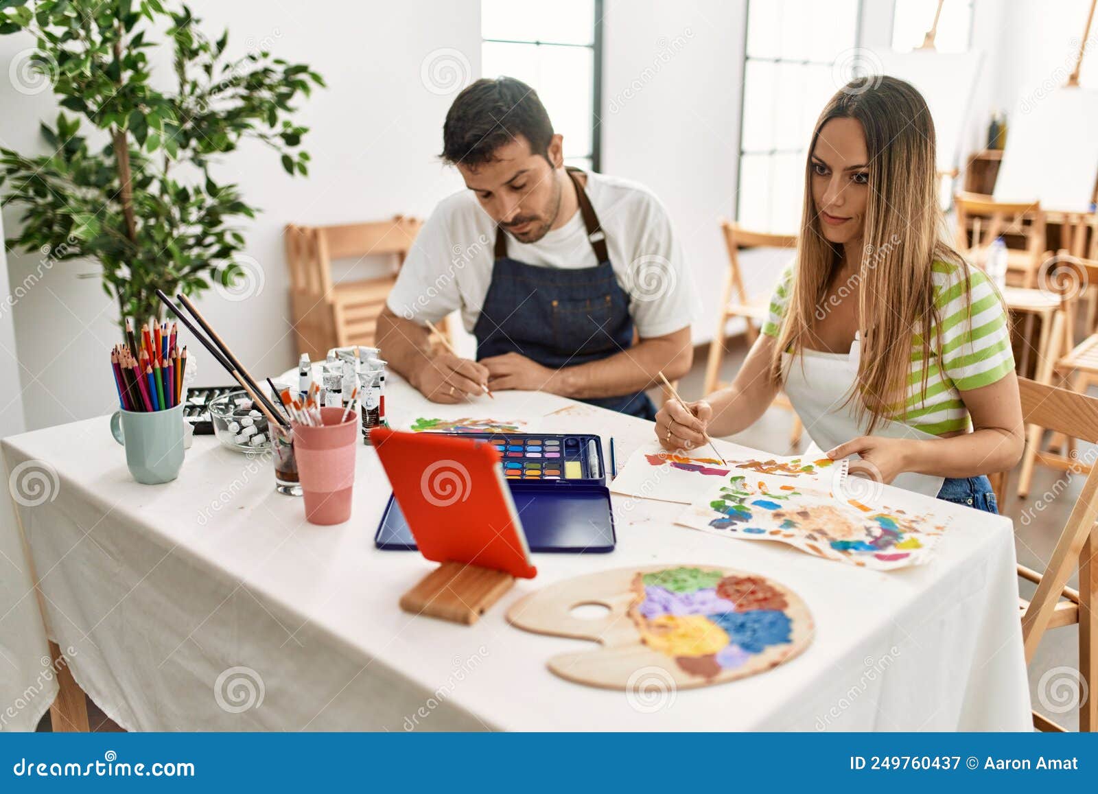 Two Students Having Online Paint Class Using Touchpad Sitting on the