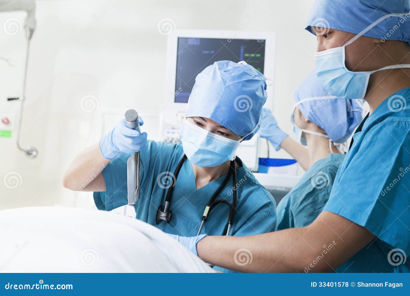Two Surgeons Working at the Operating Table, Holding Surgical Equipment