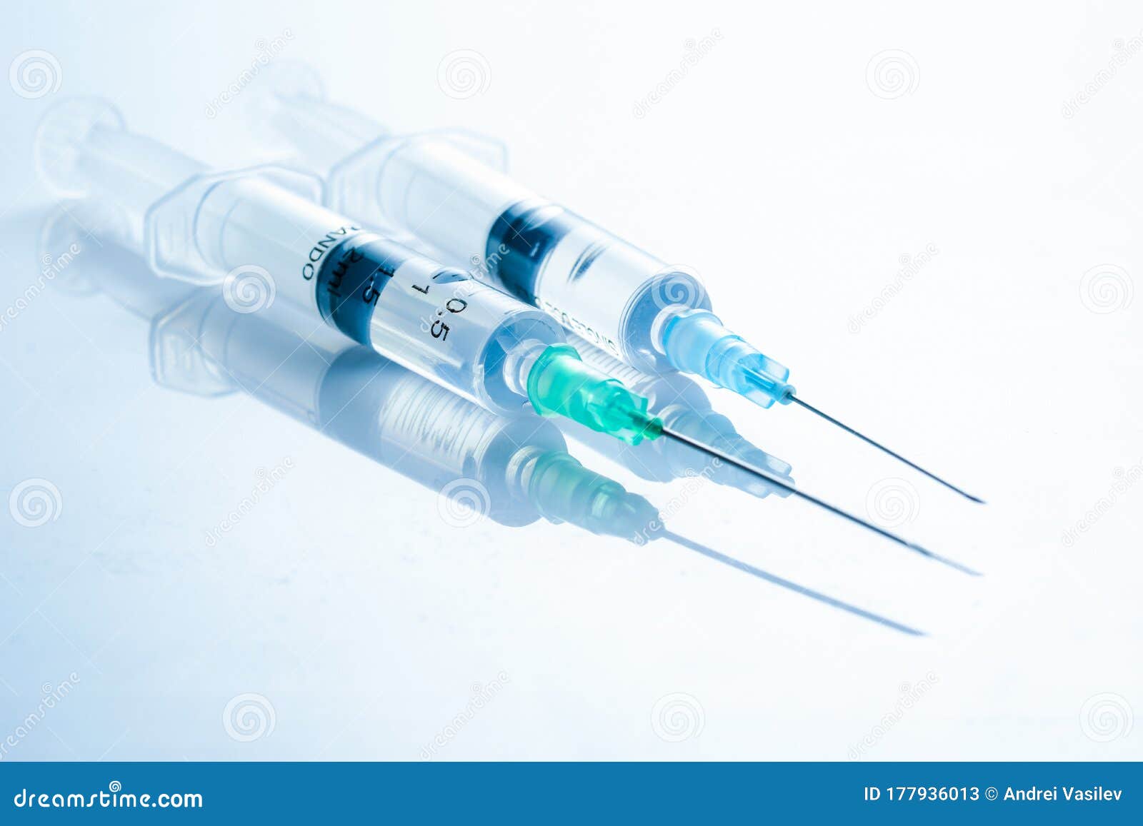 Two Syringes with Medicinal Solution, on Light Blue Background with