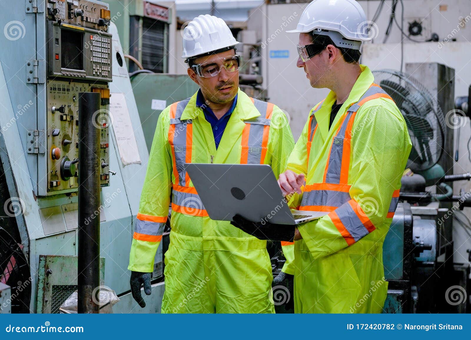 Two Technician Men with Safety Uniform Discuss about the Machine