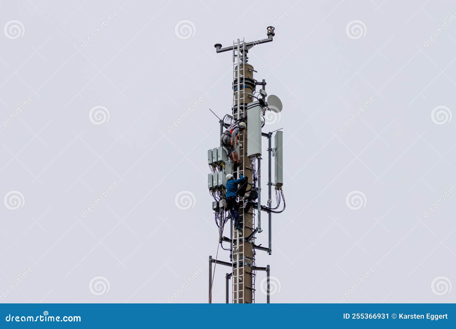 Telekom Technicians Perform Work on a Transmission Tower Stock Image