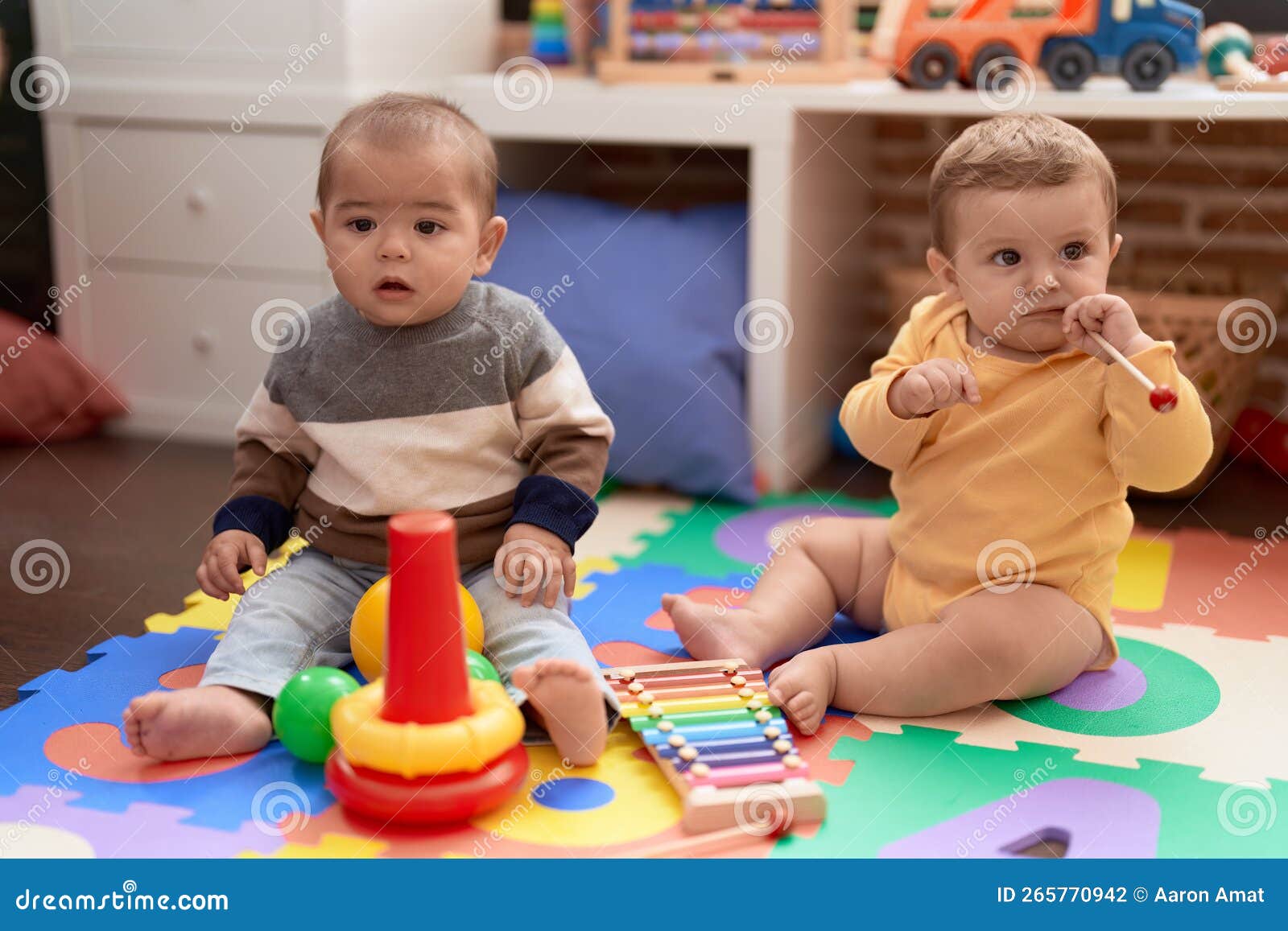 Two Toddlers Playing with Ball and Xylophone at Kindergarten Stock
