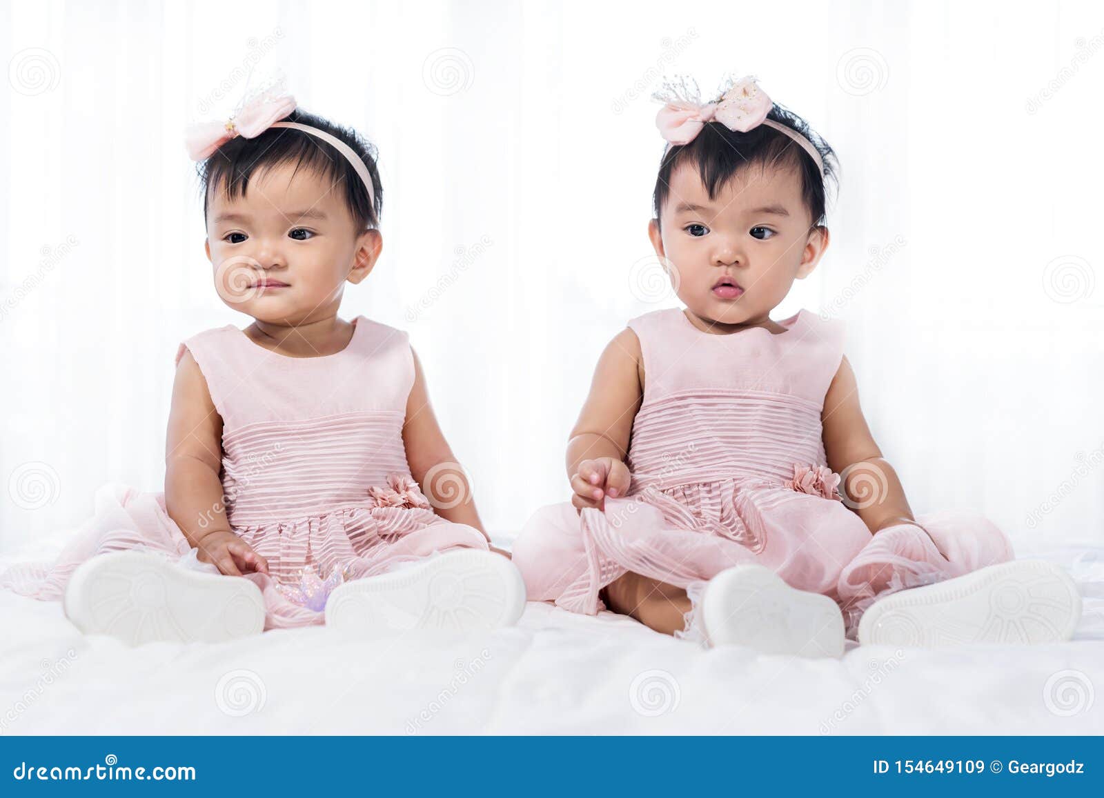 Two Twin Babies in Pink Dress on Bed Stock Image Image of cheerful