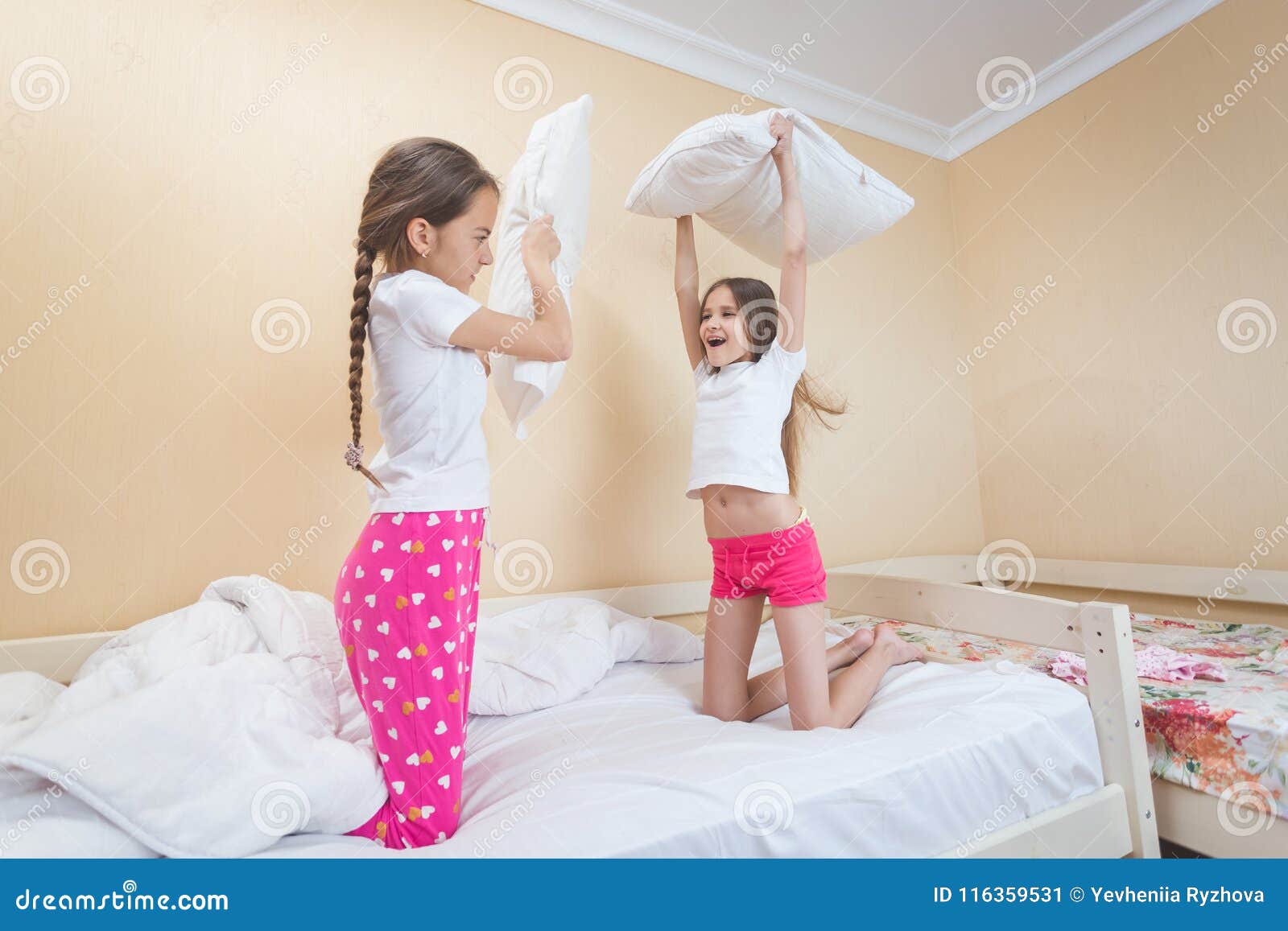 Two Twins Sisters Fighting With Pillows In Bedroom Stock Image Image