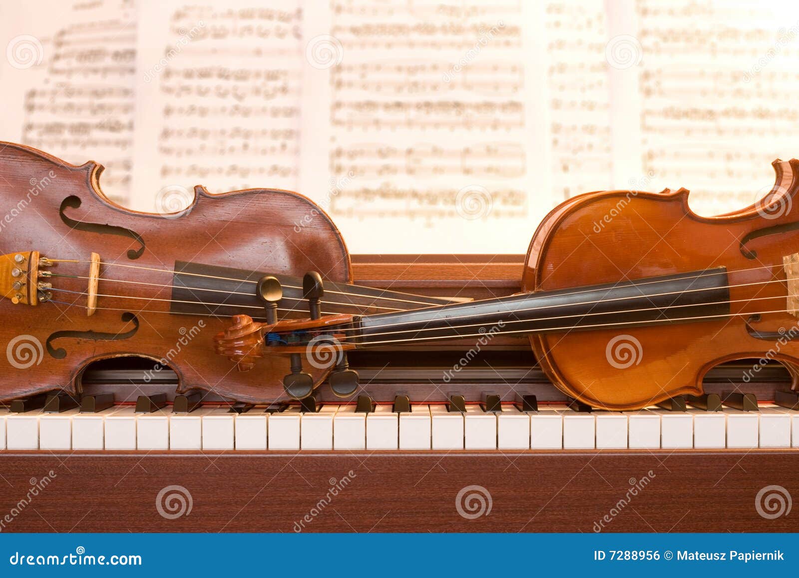 two violins on piano keys