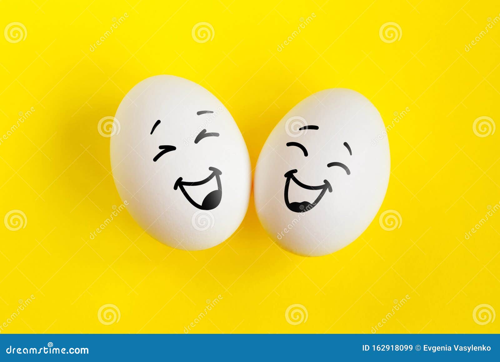 two white eggs on yellow background concept. emotions laughter and happiness.
