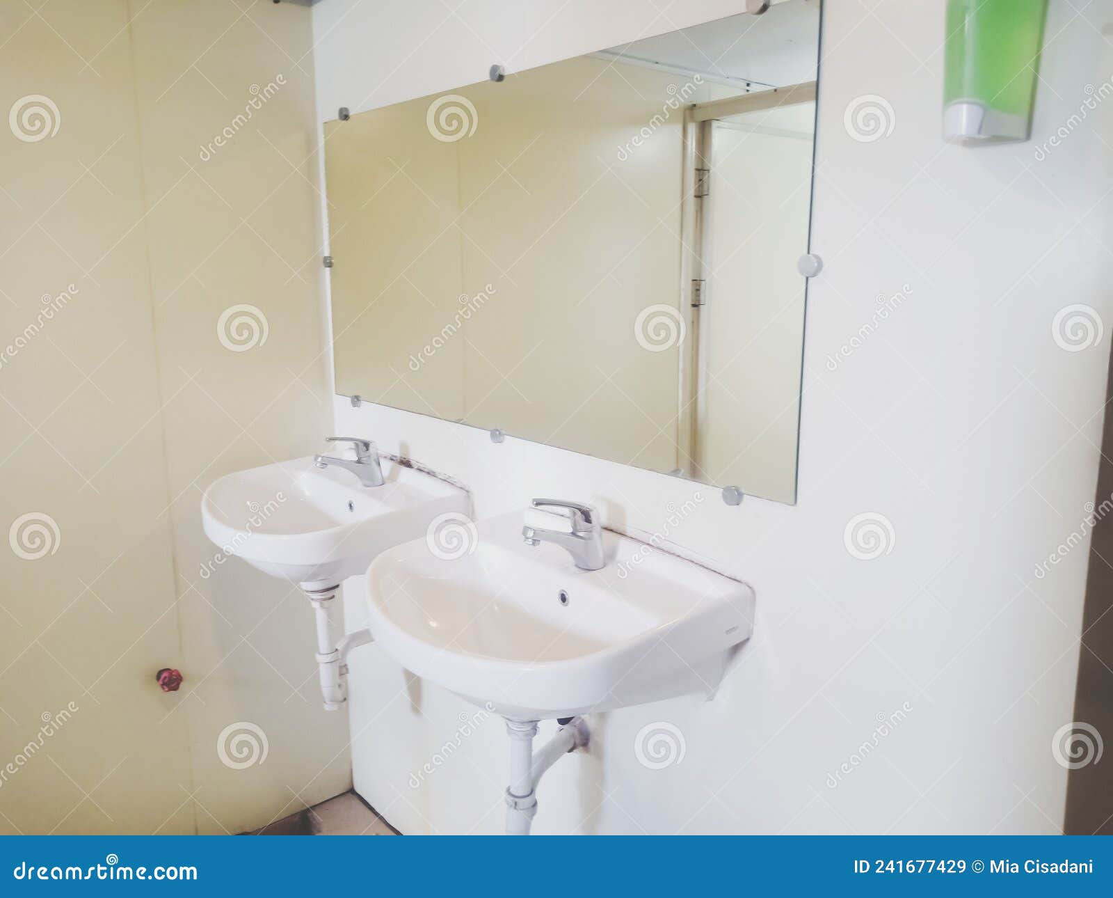 two white sinks and mirror on the public toilet