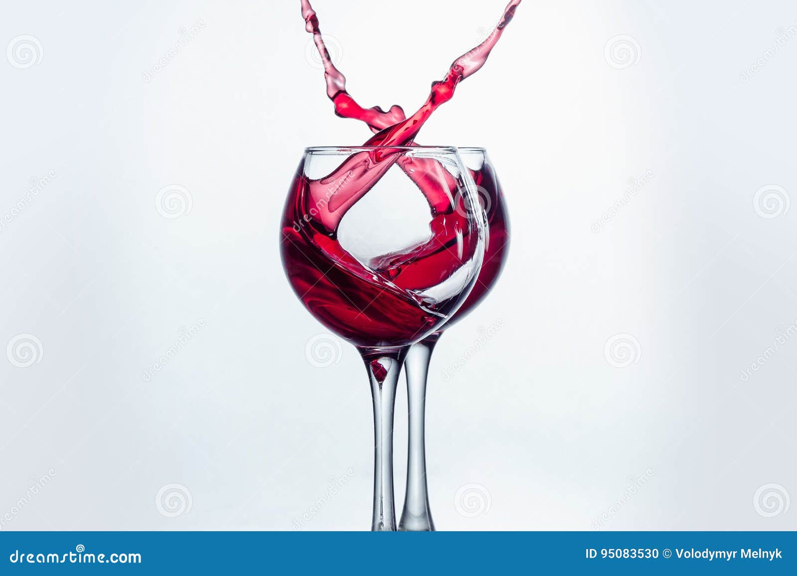 Two Wine Glasses in Toasting Gesture with Big Splashing. Stock Photo