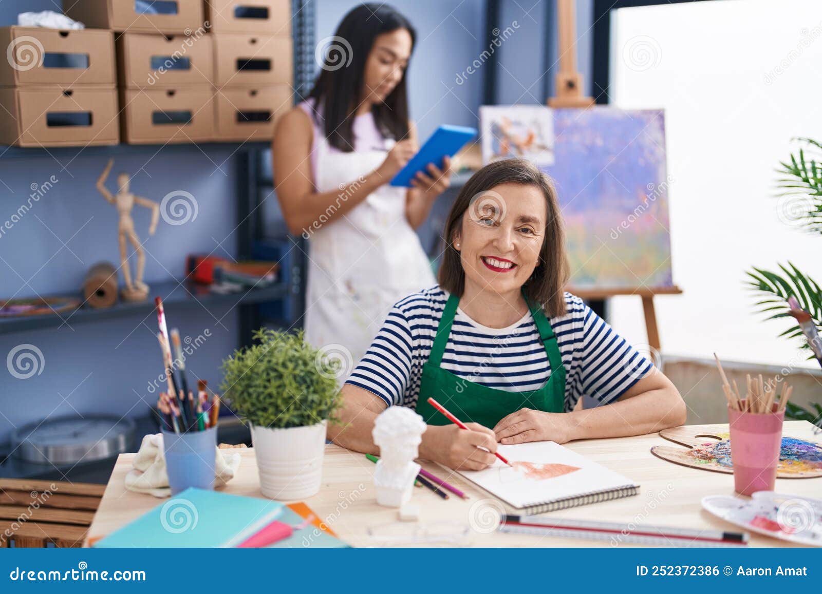 Two Women Artists Using Touchpad Drawing on Notebook at Art Studio