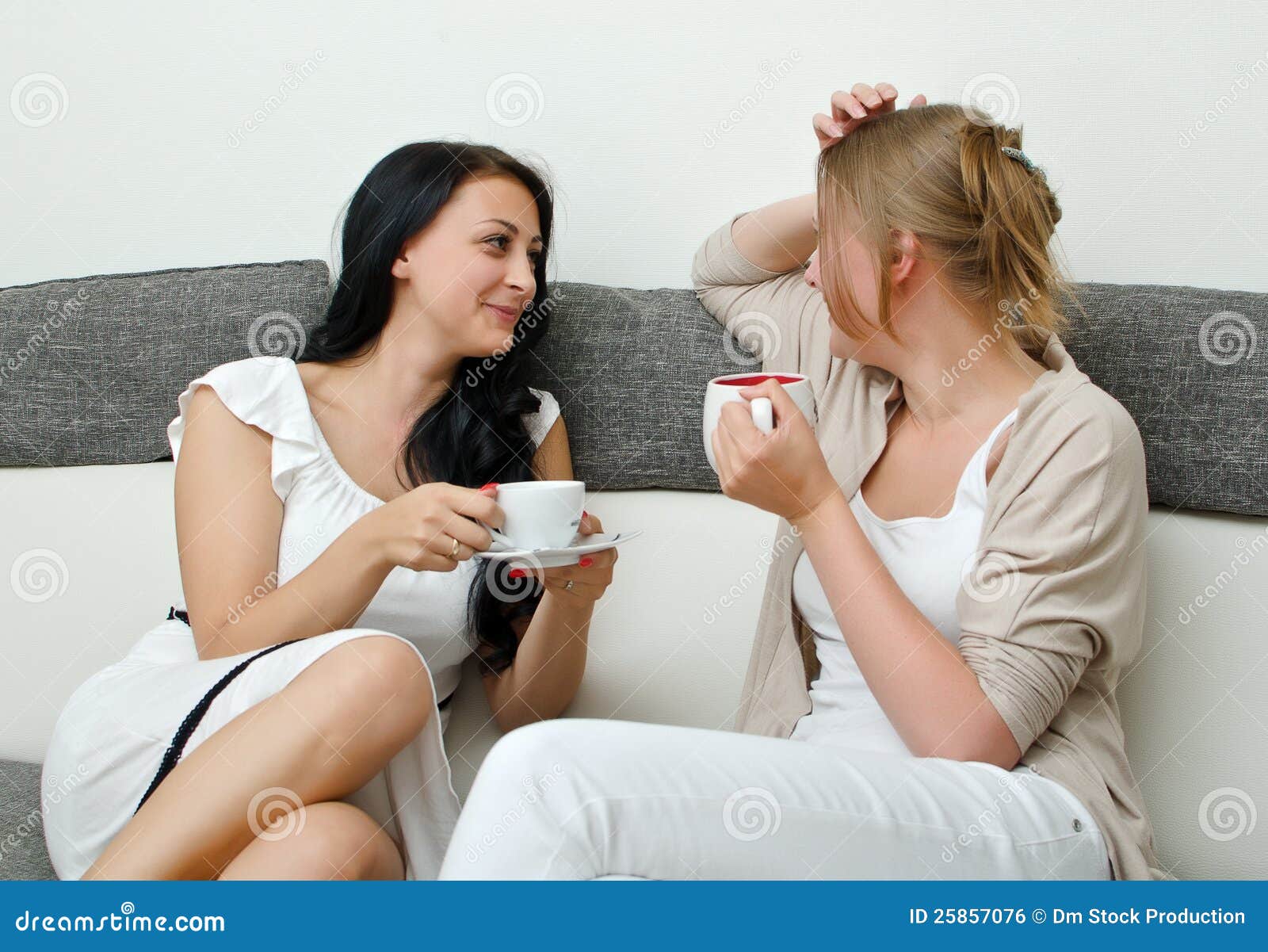 Two women friends chatting over coffee at home