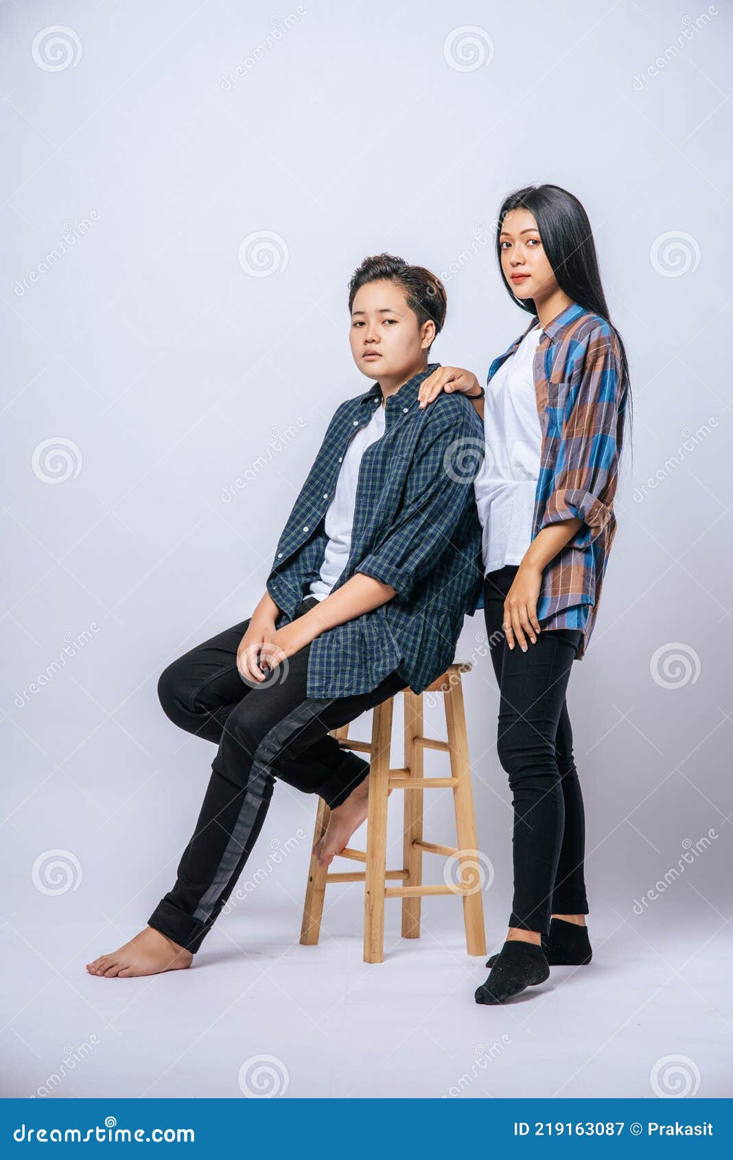 Two Women Lovers Grab Another Shoulder and Sit in a Chair Stock Image