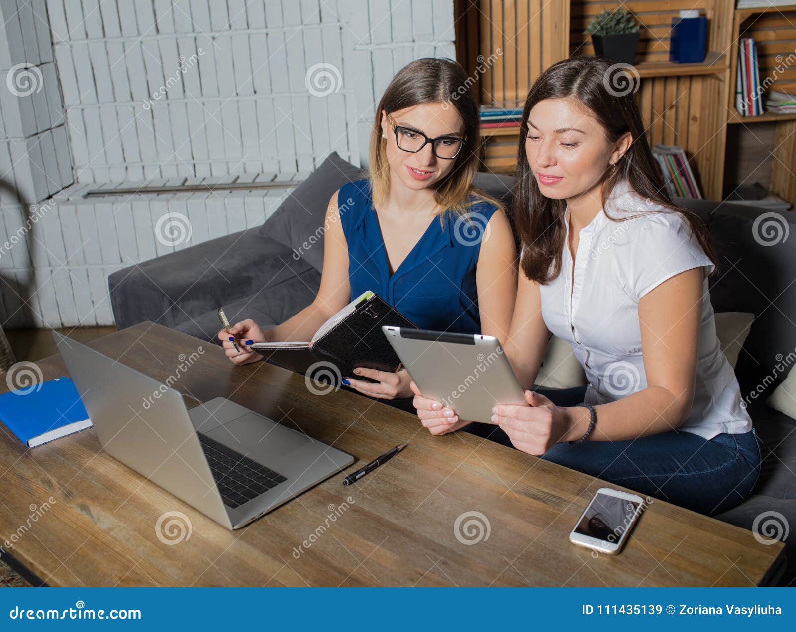 two women managers preparing to conference using net-book and touch pad