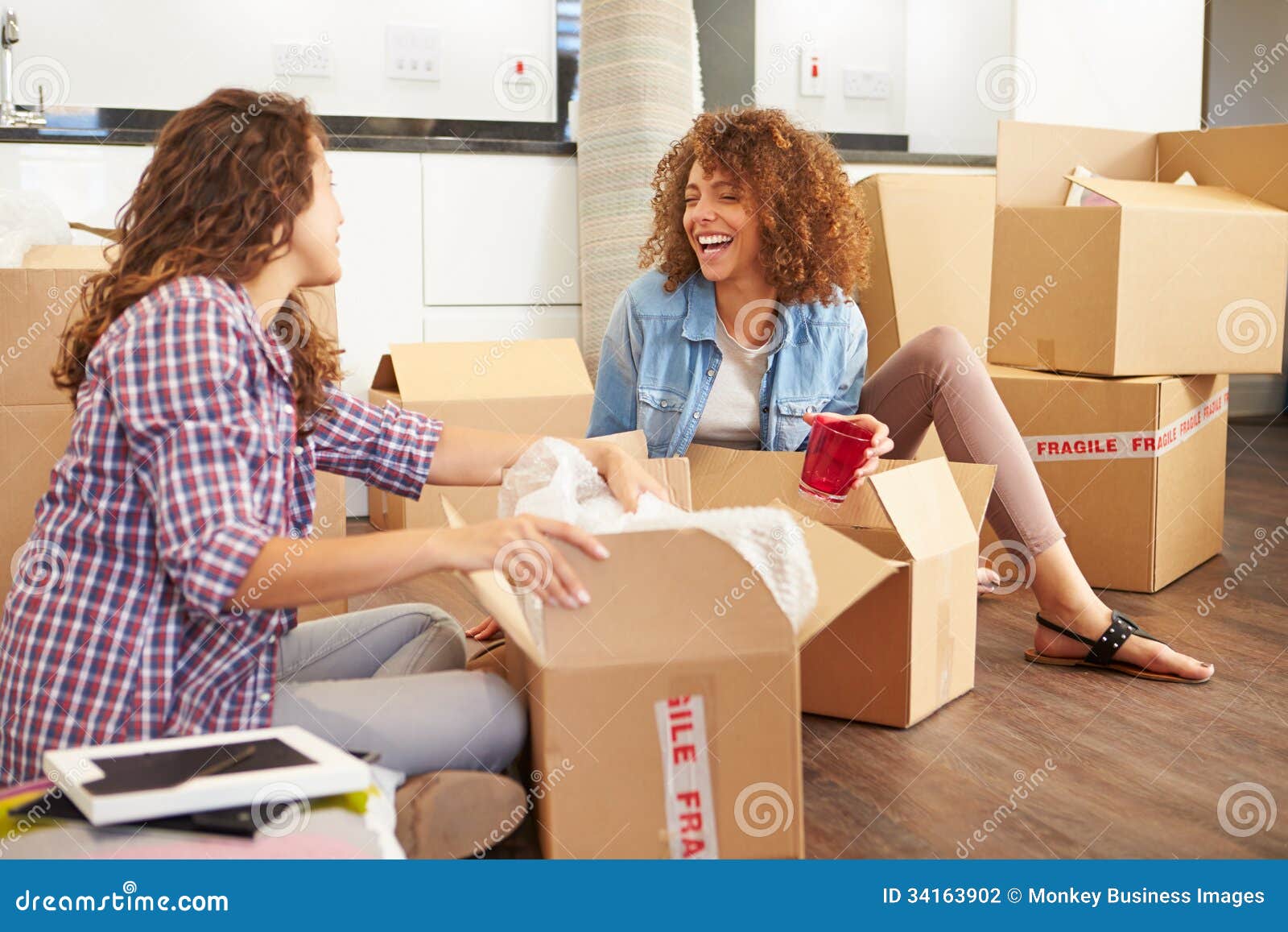 Two Women Moving Into New Home And Unpacking Boxes Royalty-Free Stock