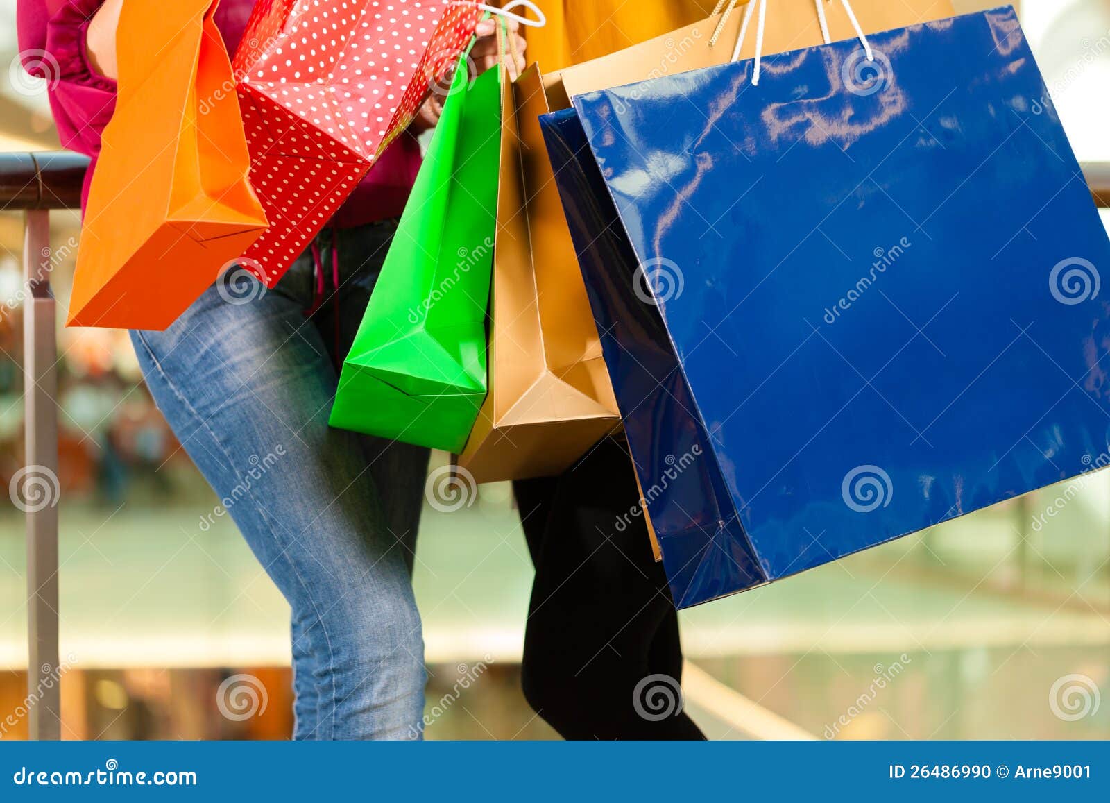 two women shopping with bags in mall