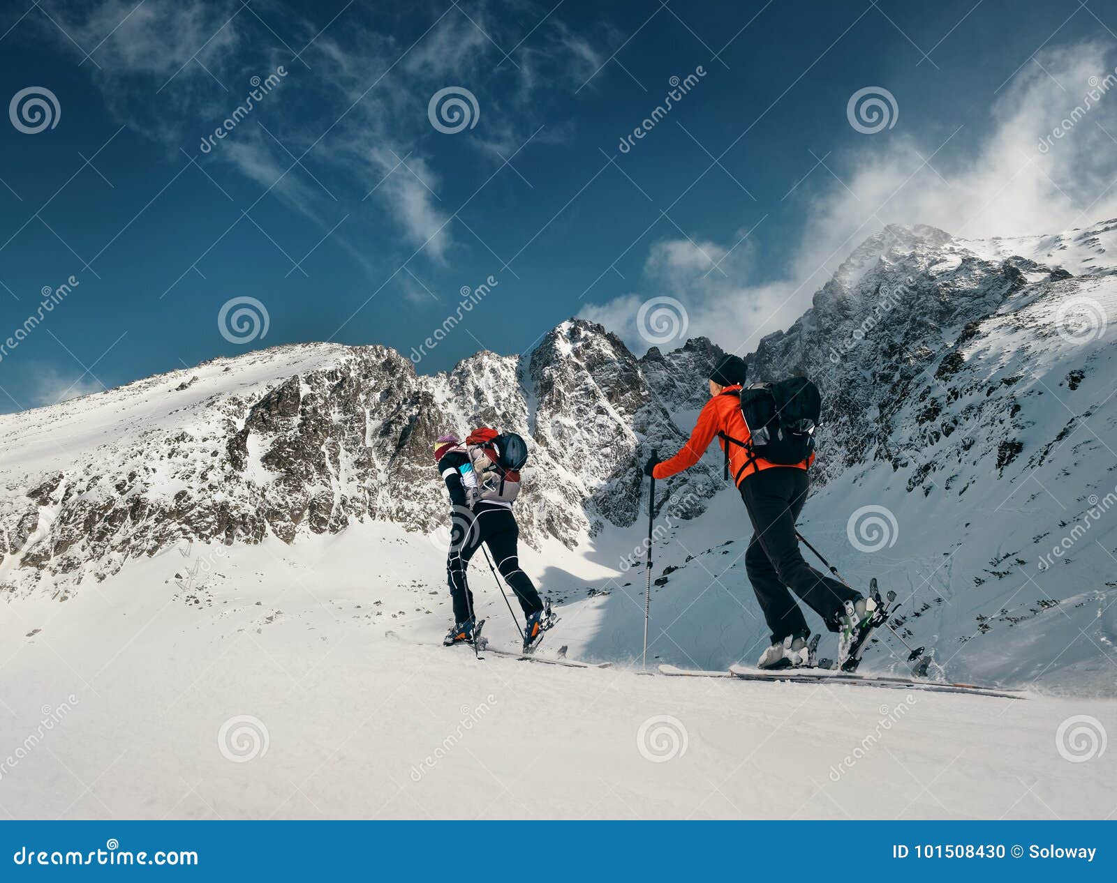 two women ski walkers go up on the mountain top