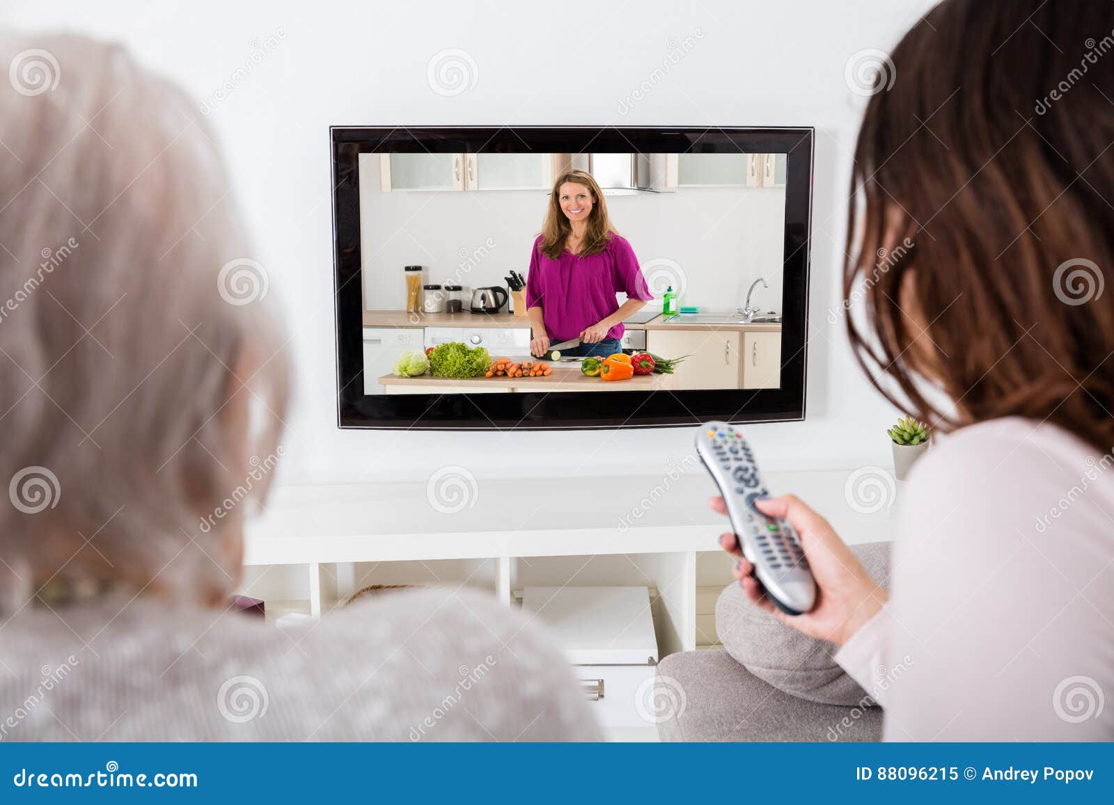two women watching cooking show on television