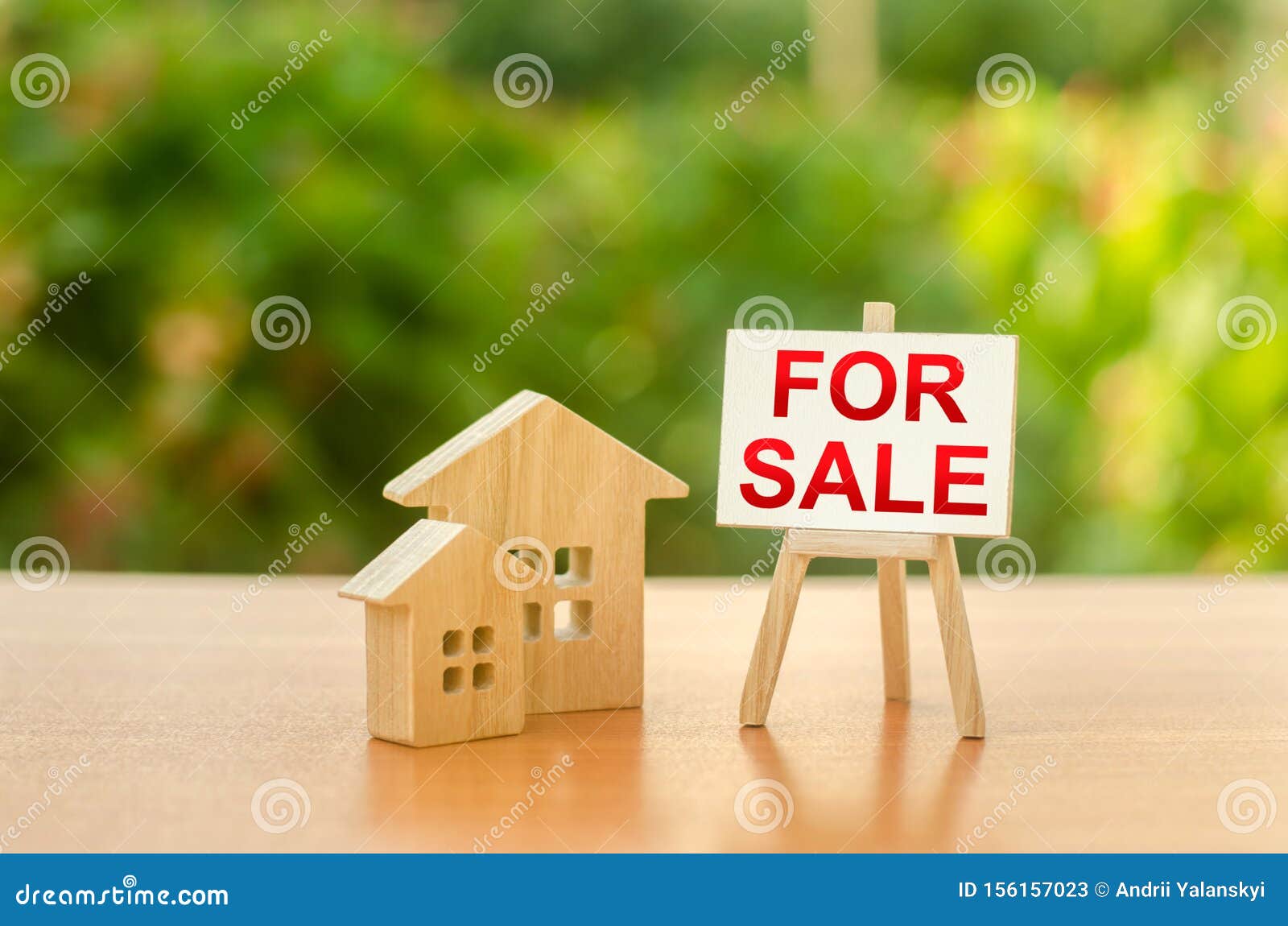 two wooden houses and a sign stand with the word sale on the background of nature. selling a home. sell real estate and property