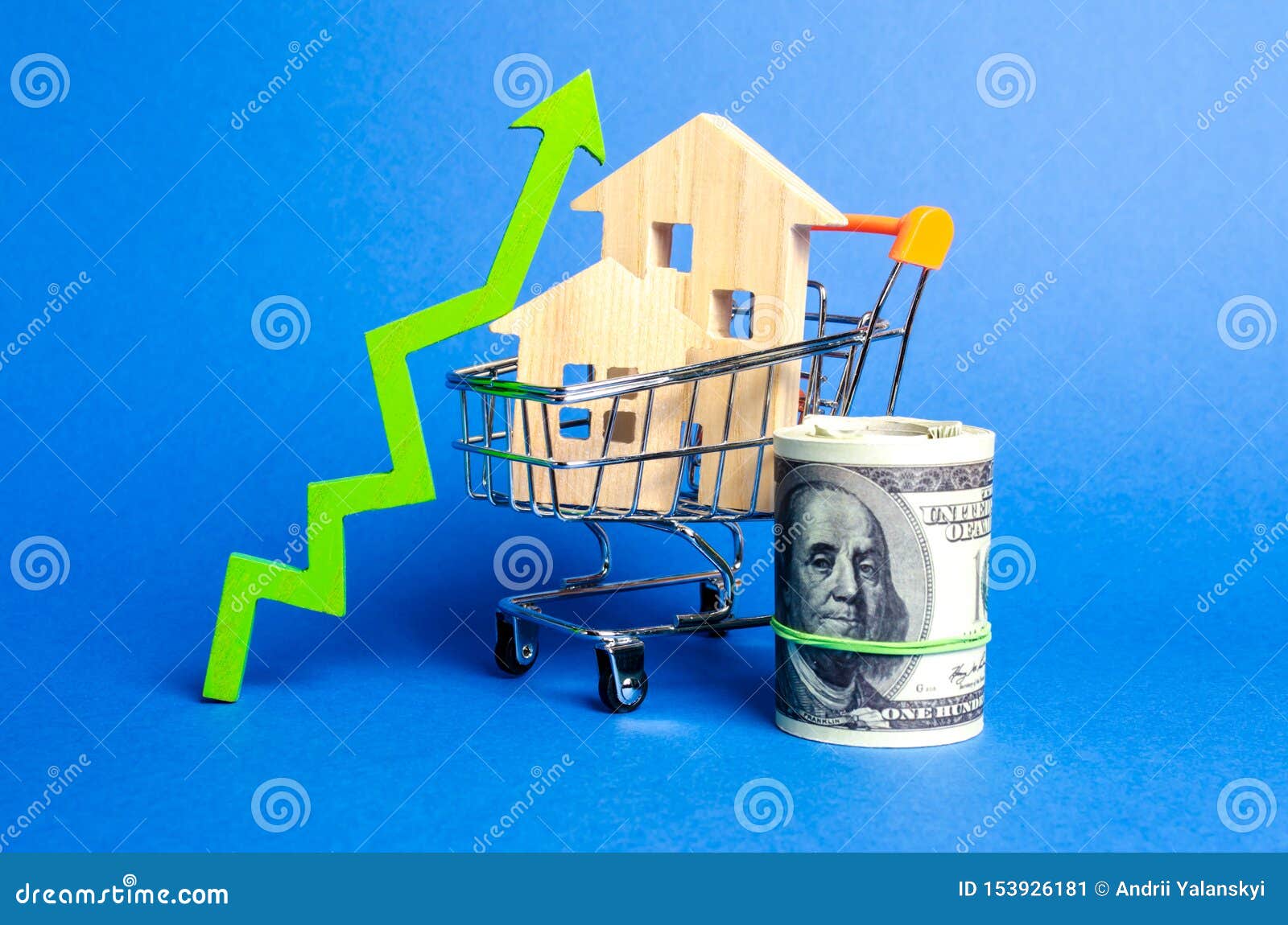 two wooden houses in a trading cart and green arrow up and money bundle. increasing cost and liquidity of real estate. attractive