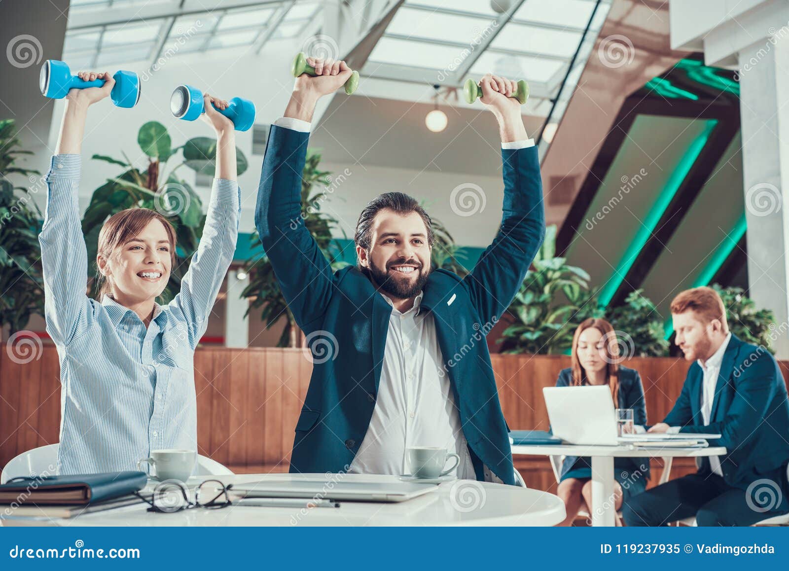 Two Workers Exercising with Dumbbells in Office. Stock Image - Image of ...