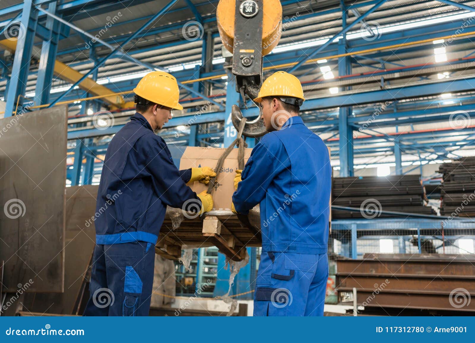 two workers handling heavy loading lifted by crane