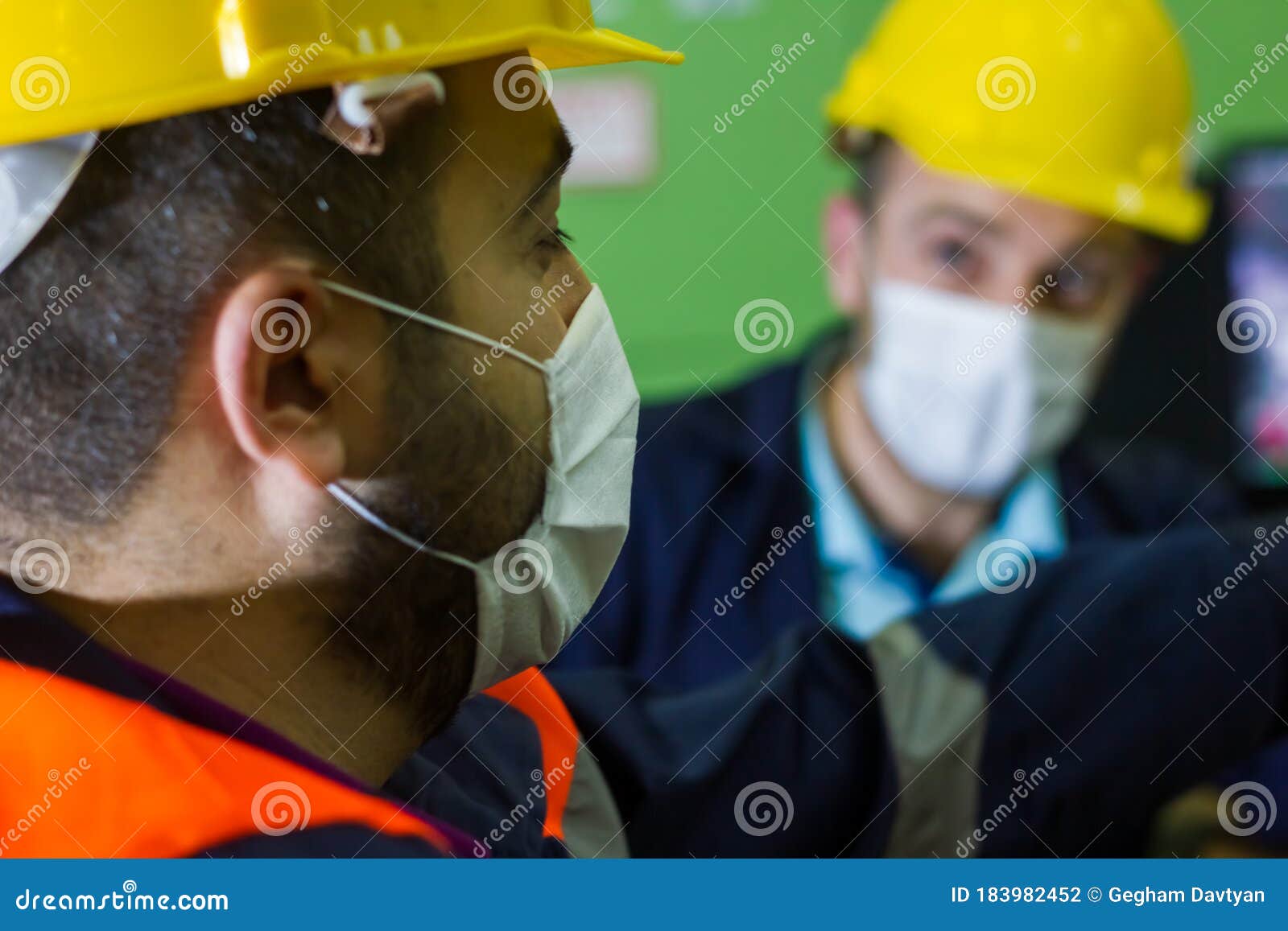 The Two Workers in Protective Masks and Yellow Helmets in Control Panel
