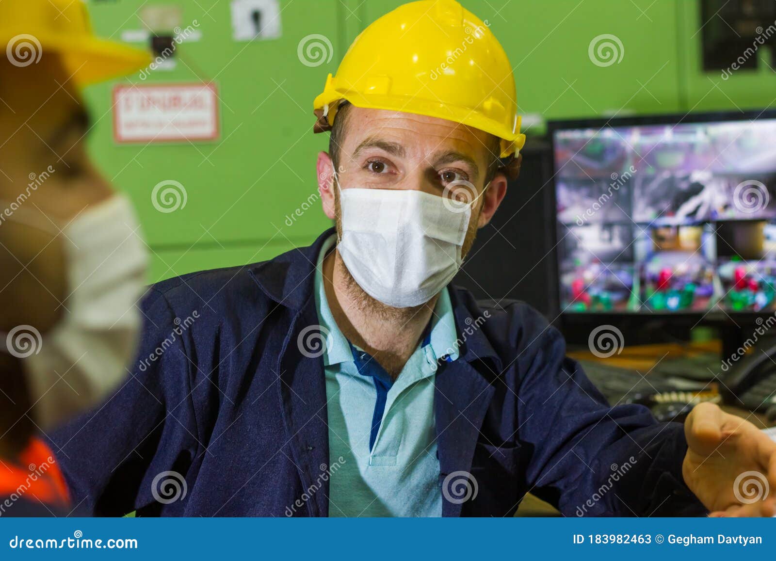 The Two Workers in Protective Masks and Yellow Helmets in Control Panel