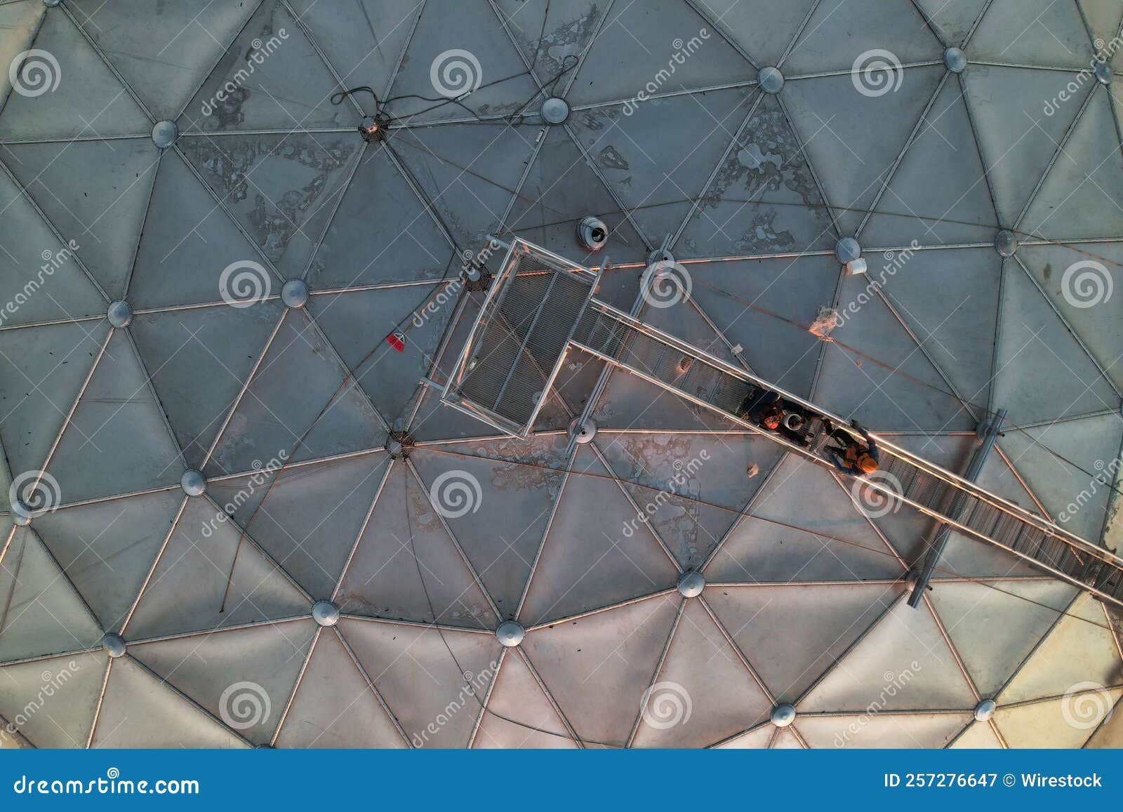 Workers on Top of a Sphere Dome Building Near a Coast Stock Image