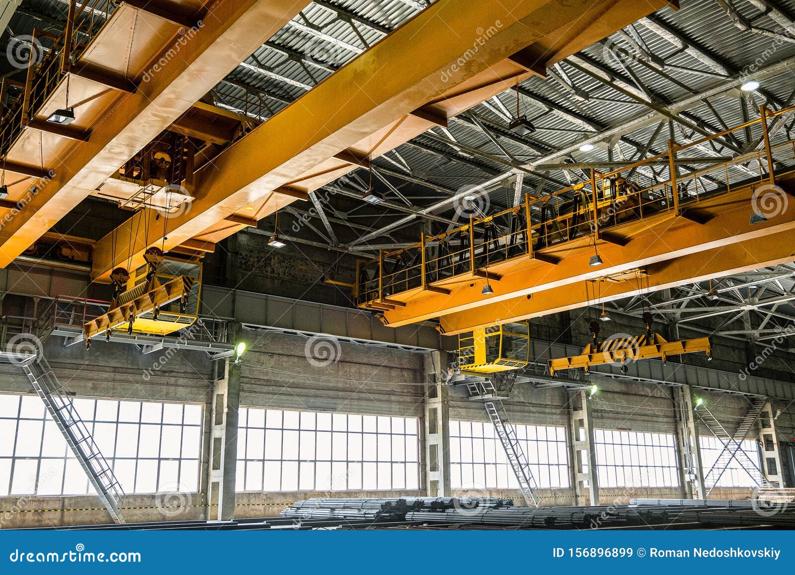 two yellow overhead cranes in engineering plant shop