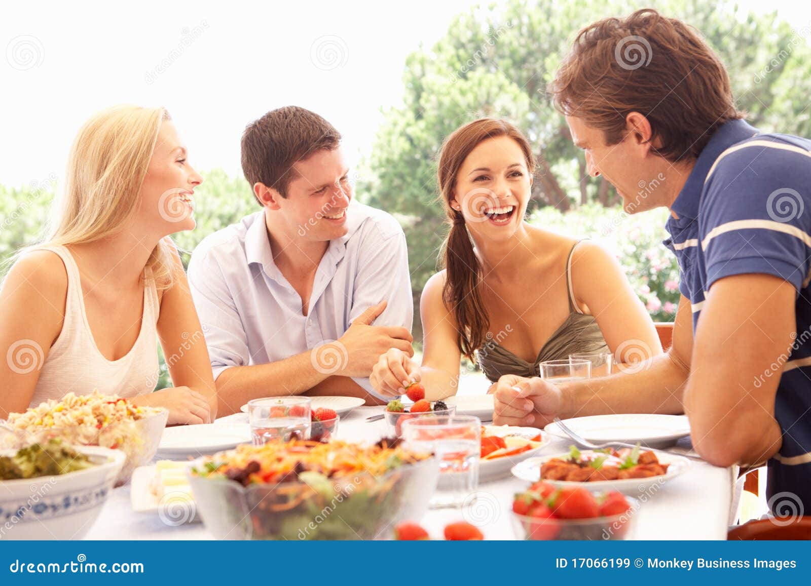 two young couples eating outdoors