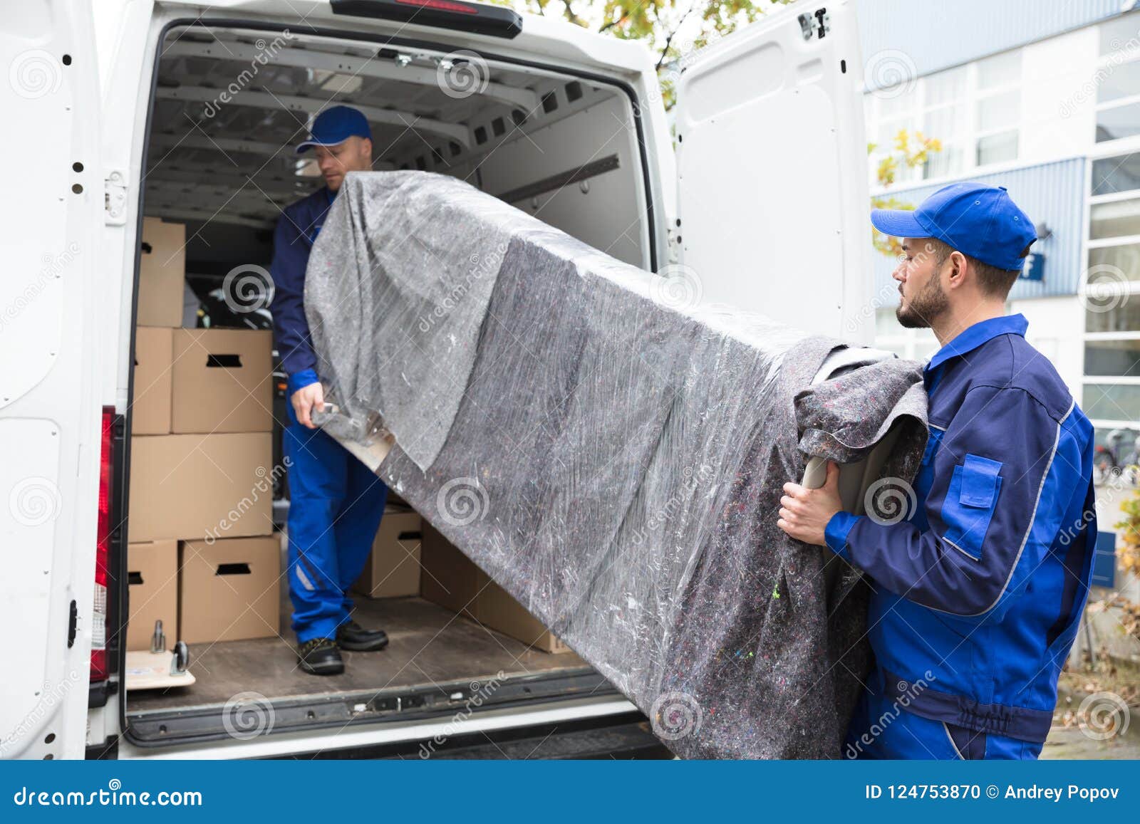 two delivery men unloading furniture from vehicle